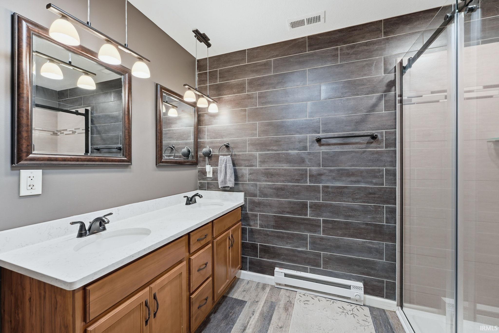 Double vanity with white countertops and wood-finish cabinetry