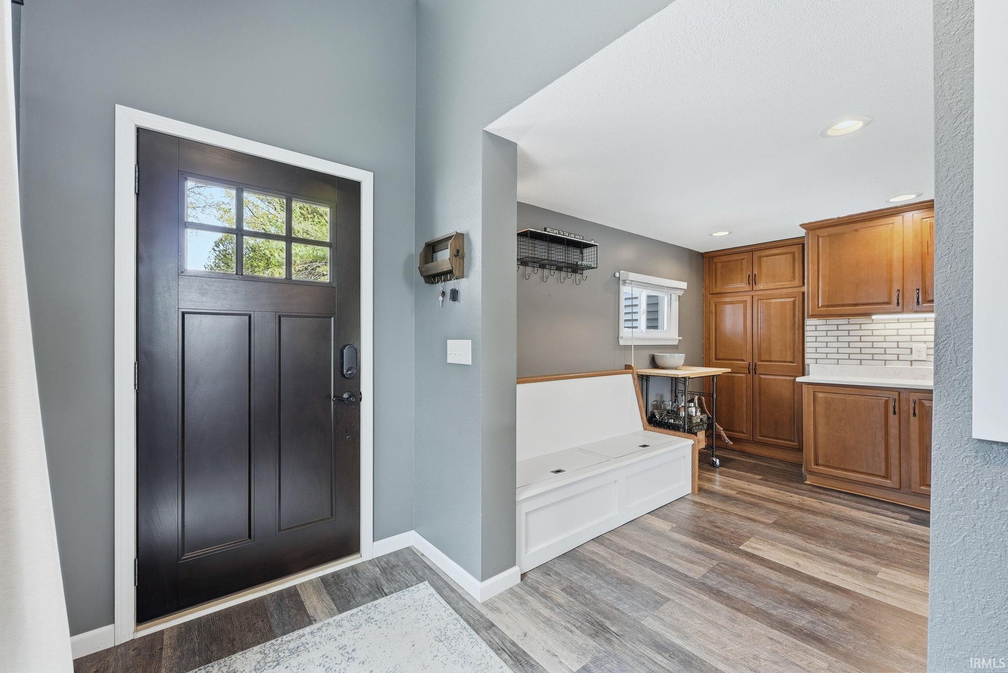 Front entry with dark paneled door featuring multiple glass lites and a smart lock