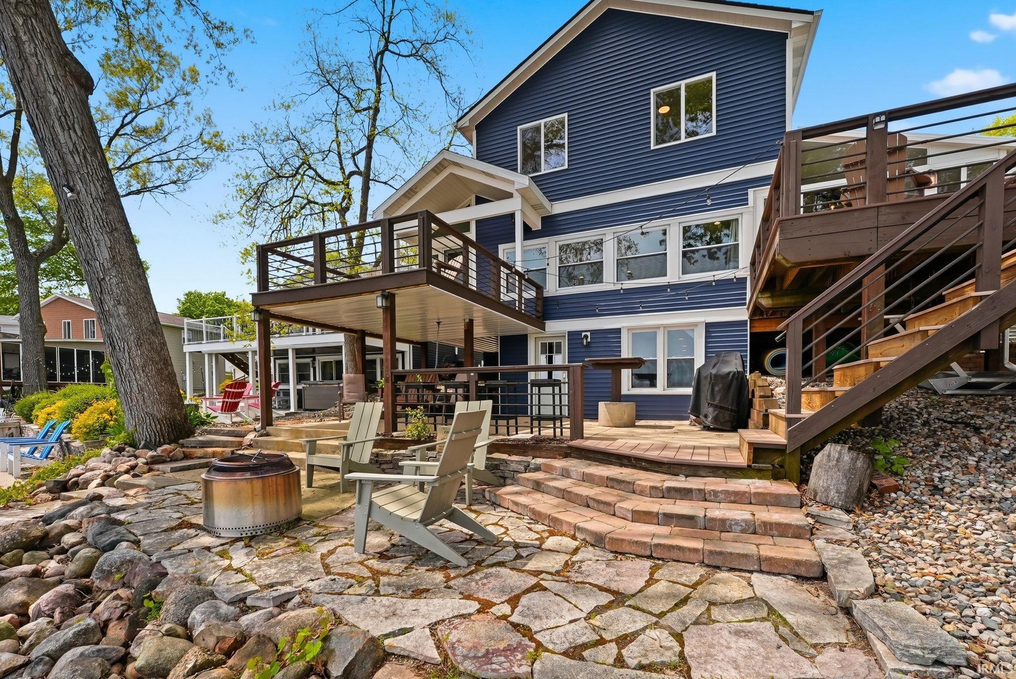 Deep blue siding exterior with multiple decks and a stone patio