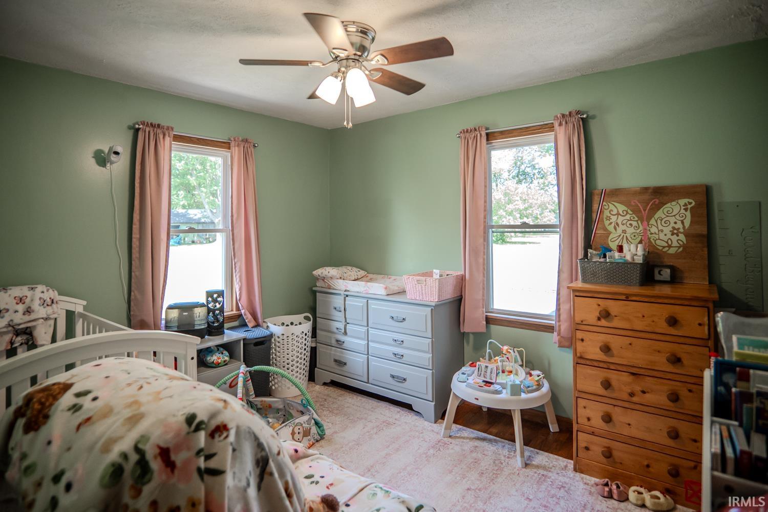 Interior room featuring light green painted walls and two double-hung windows