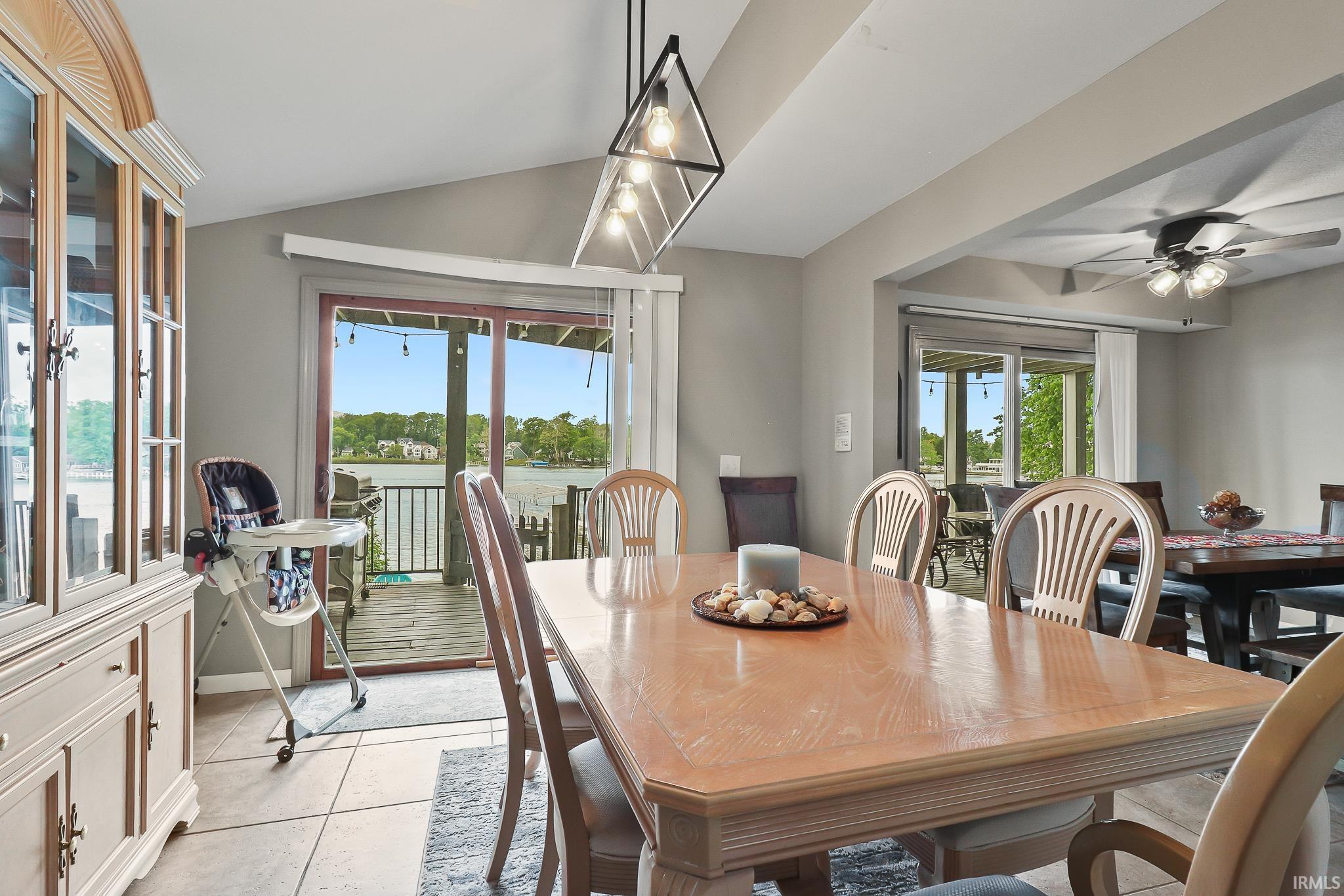 Dining area featuring a vaulted ceiling and an angular pendant light fixture