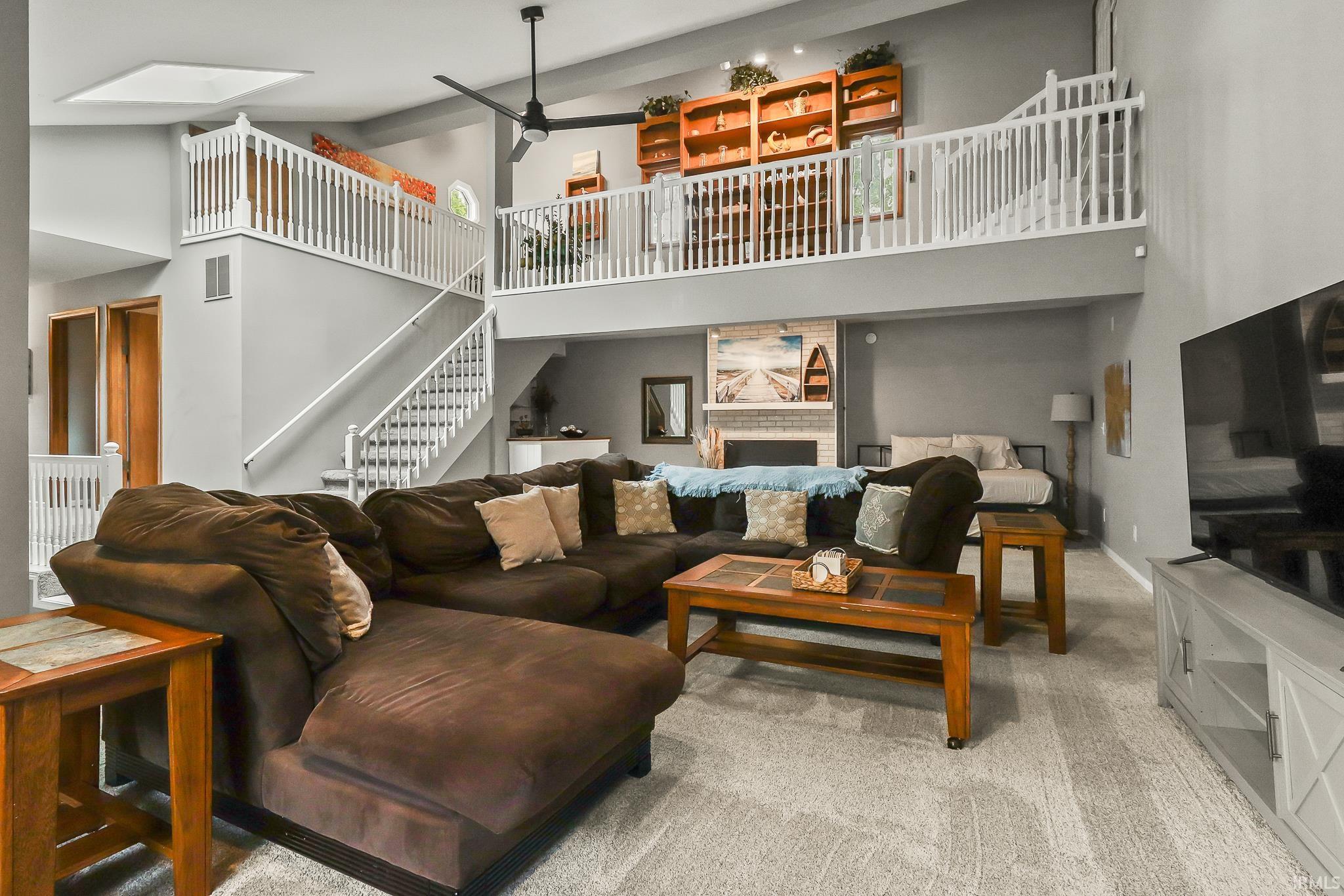 Spacious living area featuring a vaulted ceiling and loft overlook