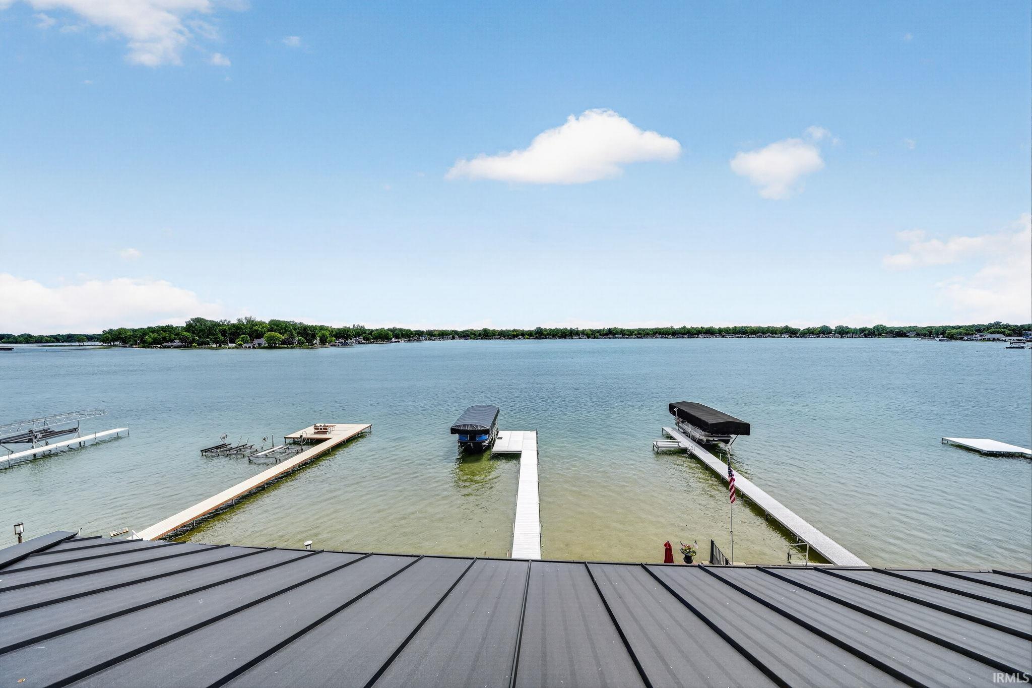 Expansive waterfront featuring multiple docks and boat lifts, complemented by a modern metal roofline