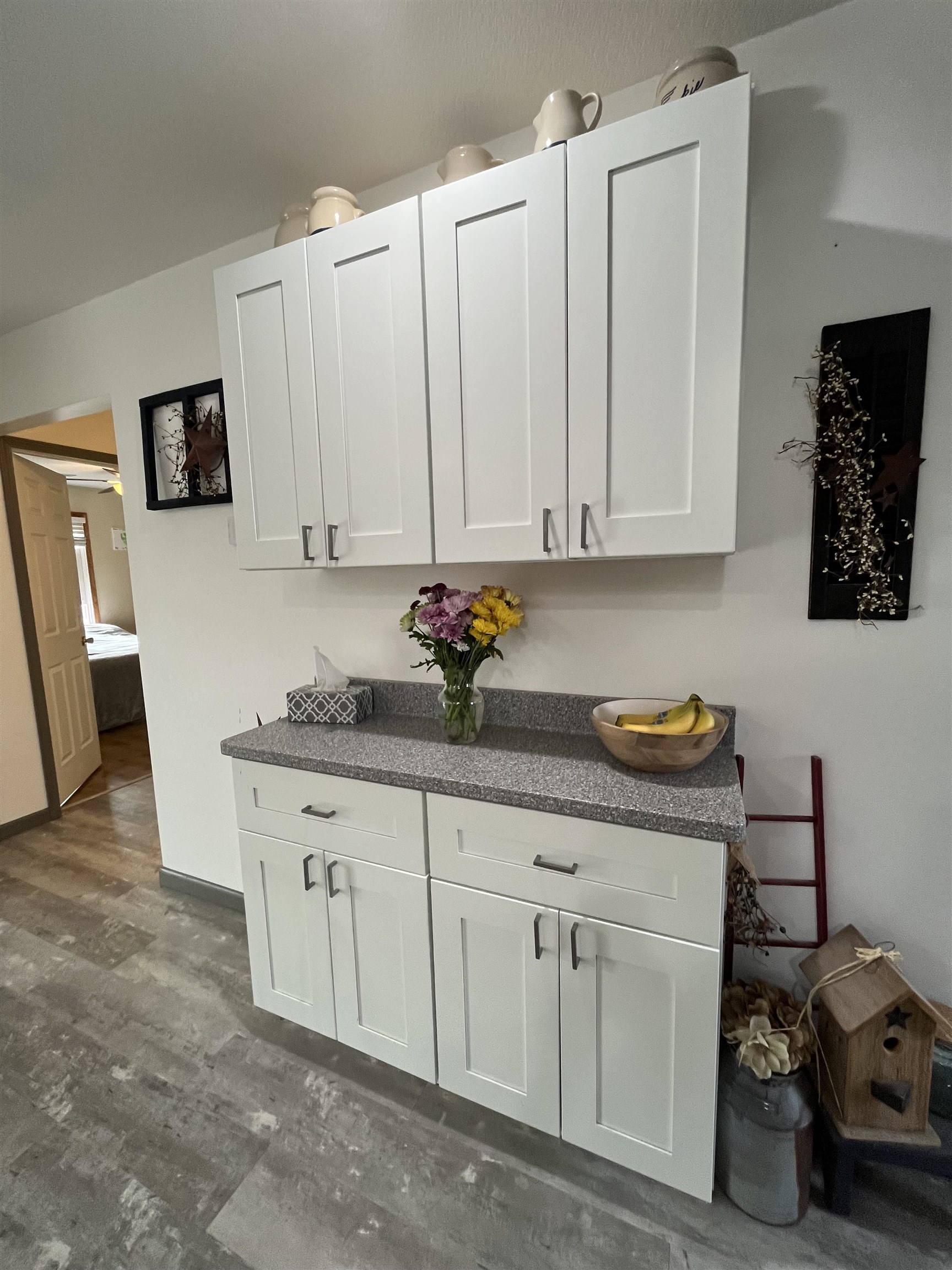 White shaker-style cabinetry with dark hardware and granite-look countertops