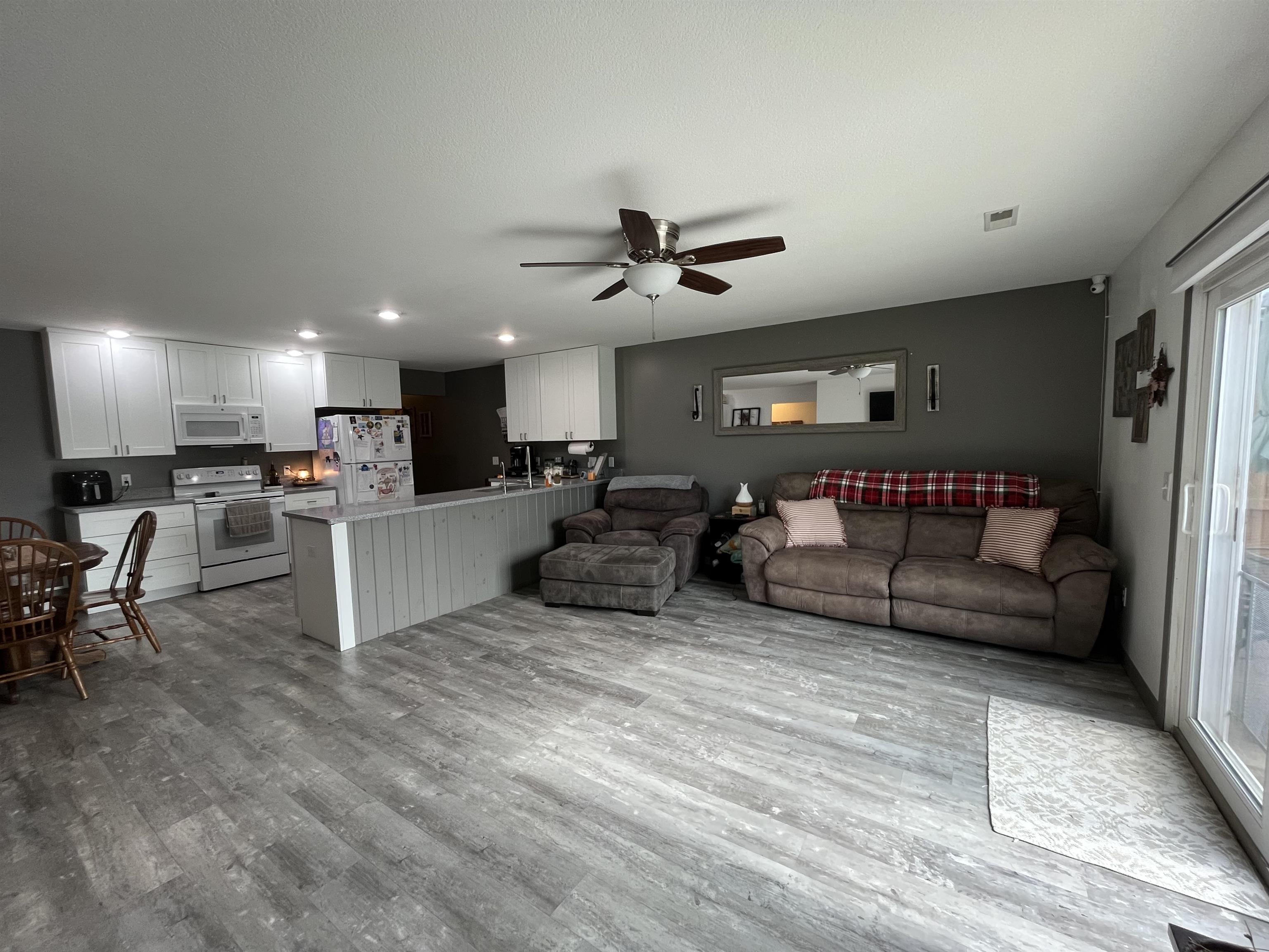 Open-concept living space featuring wood-finish flooring and recessed lighting