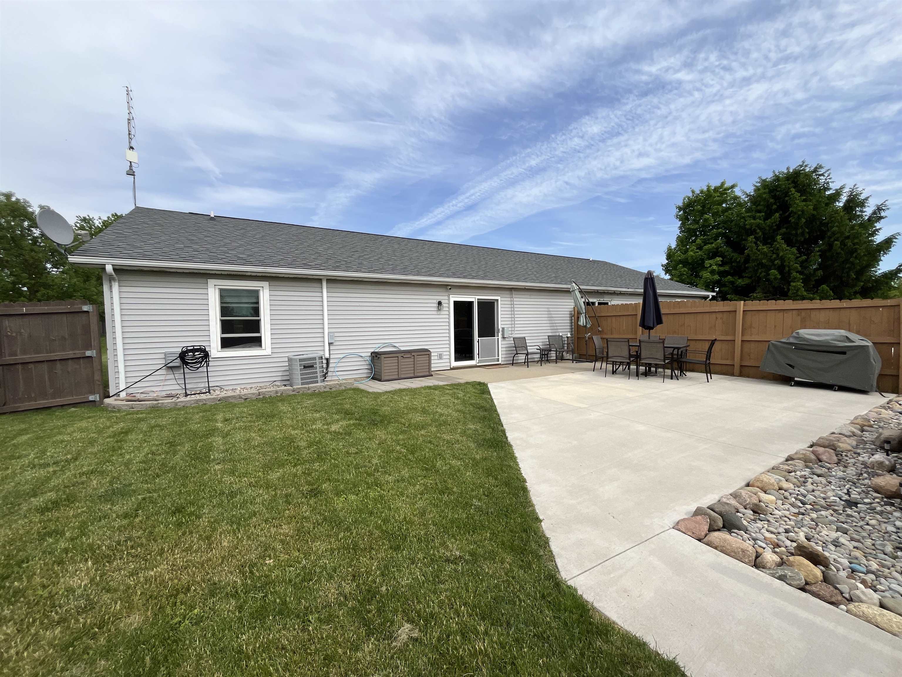Expansive concrete patio with a decorative rock border