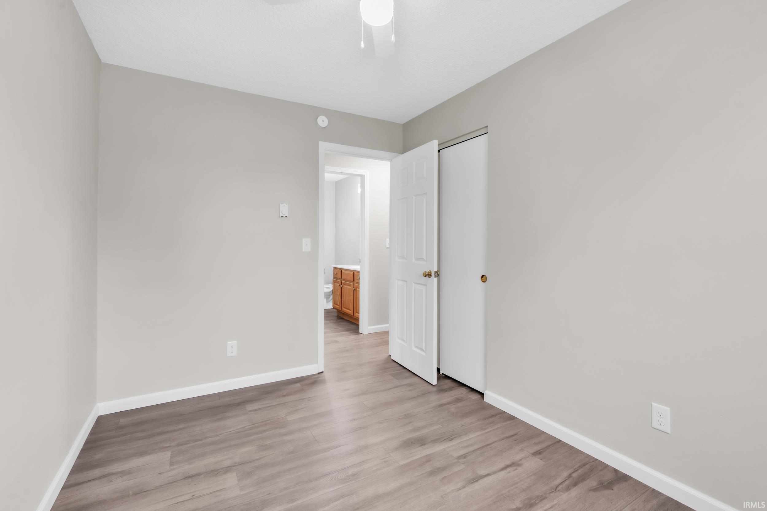 Spacious room featuring wood-finish flooring and light gray walls