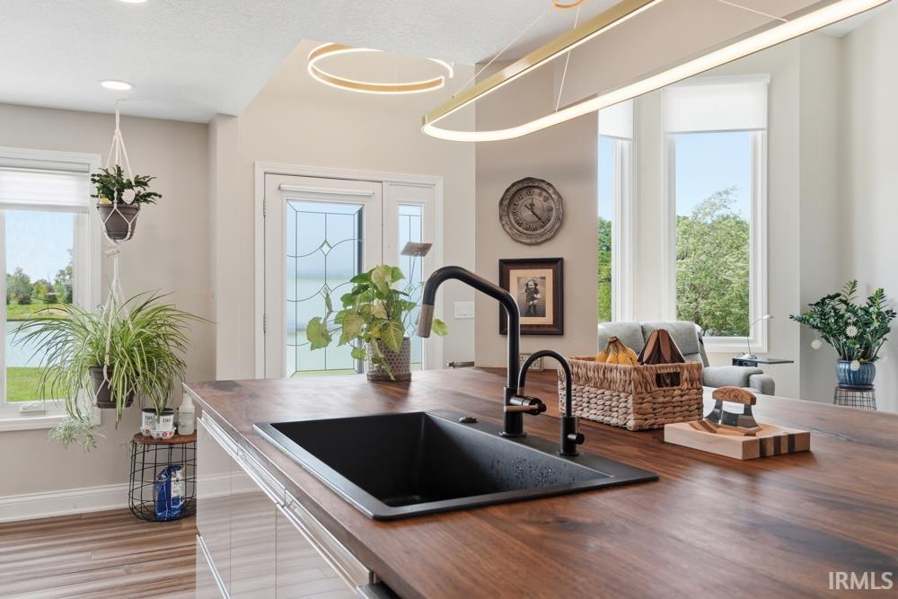 Spacious kitchen island with a dark wood-finish countertop, undermount sink, and matte black faucet