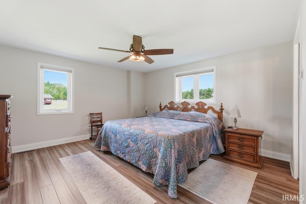 Spacious room featuring wood-finish flooring and light-toned walls