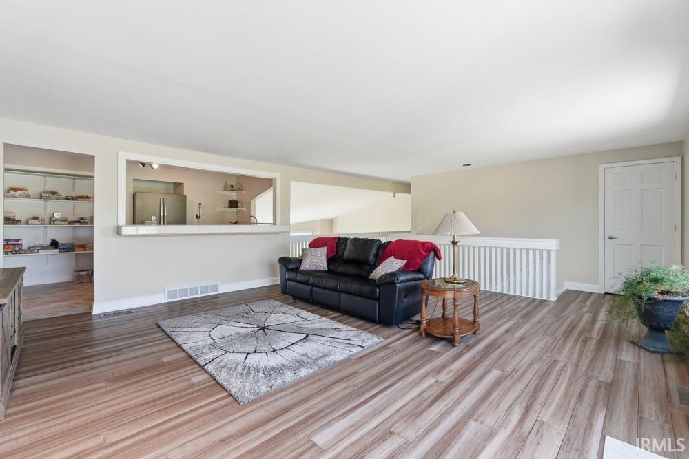 Spacious living area featuring wood-finish flooring and light neutral wall colors