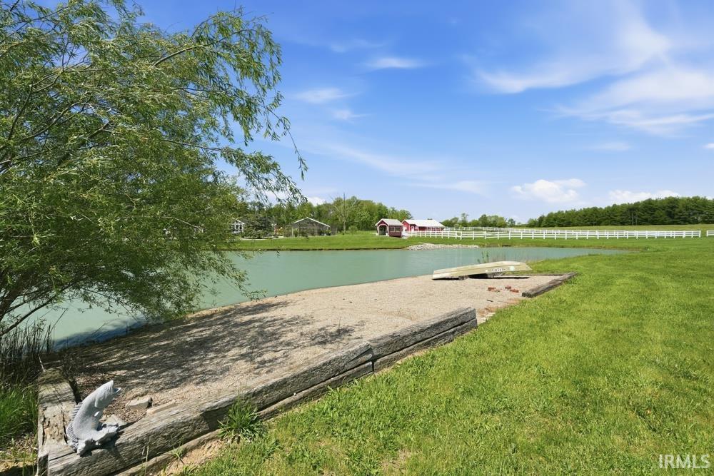 Expansive green lawn with a private pond and a concrete dock