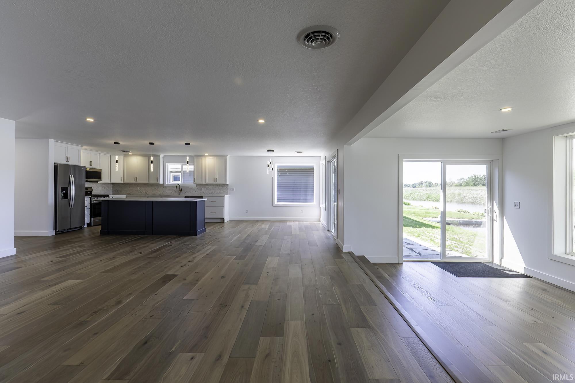 Spacious open-concept area featuring wood-finish flooring throughout