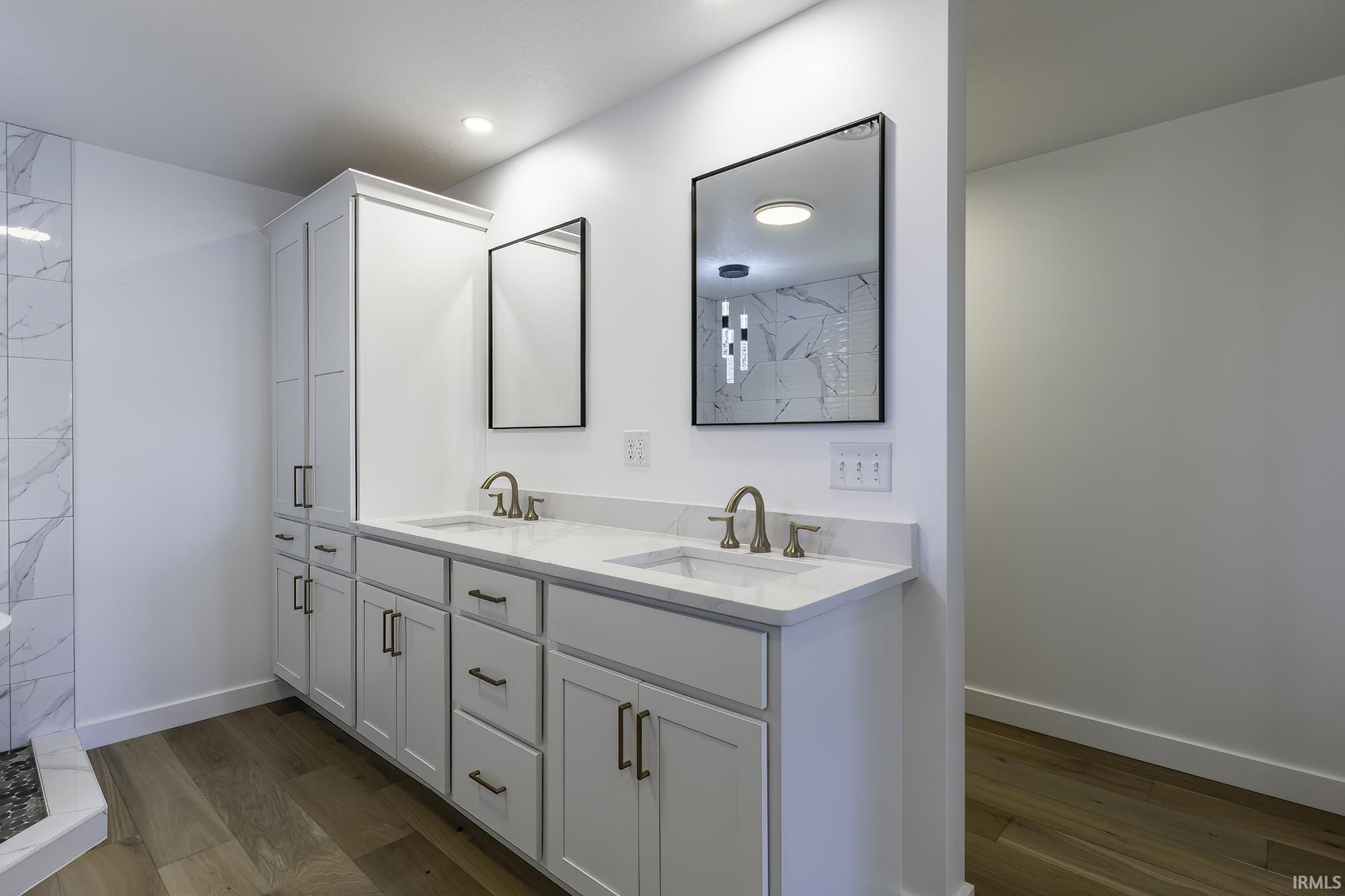 Dual vanity with white cabinetry, integrated sinks, brushed nickel fixtures, and quartz countertops