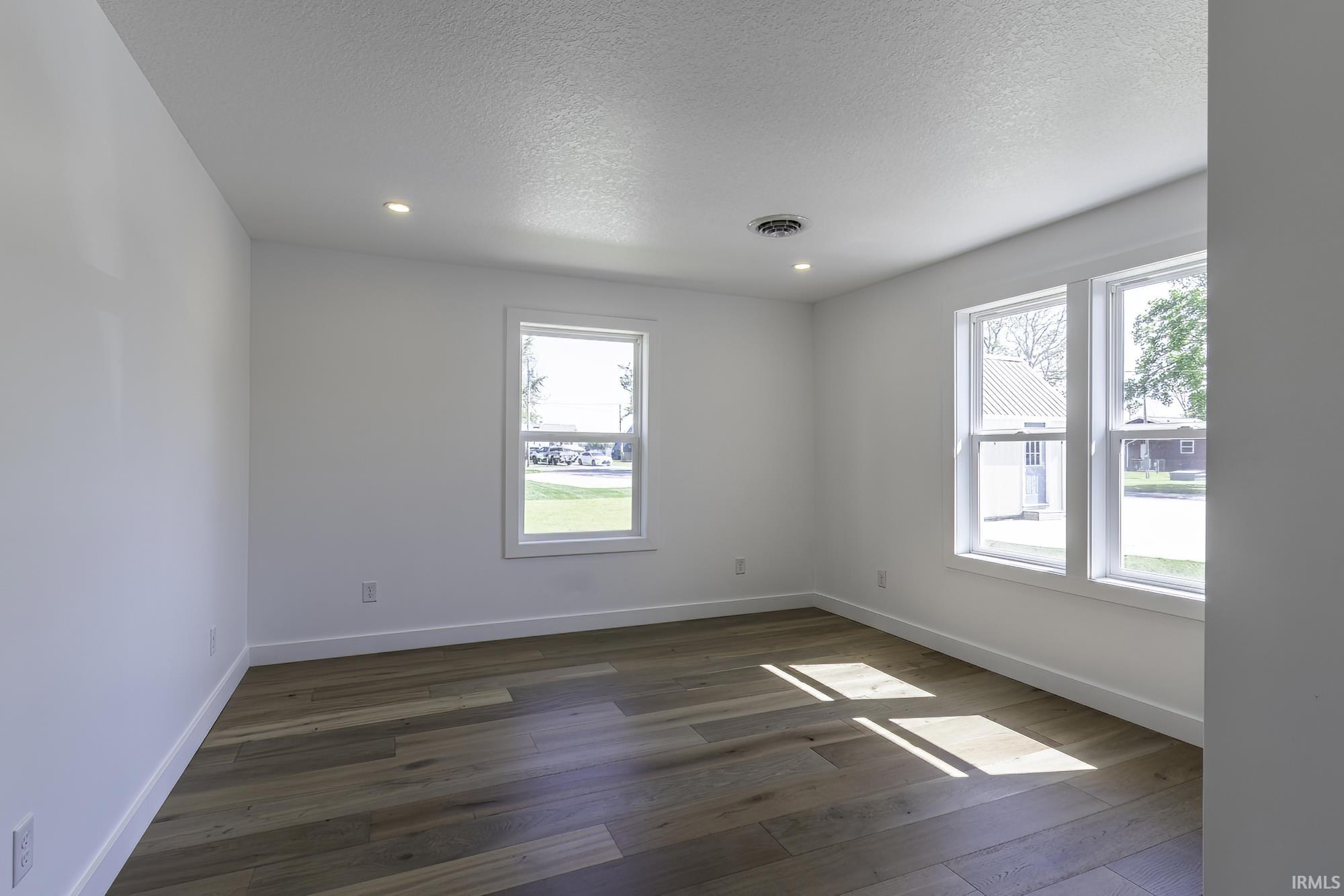 Interior room featuring wood-finish flooring, white baseboards, and neutral wall paint
