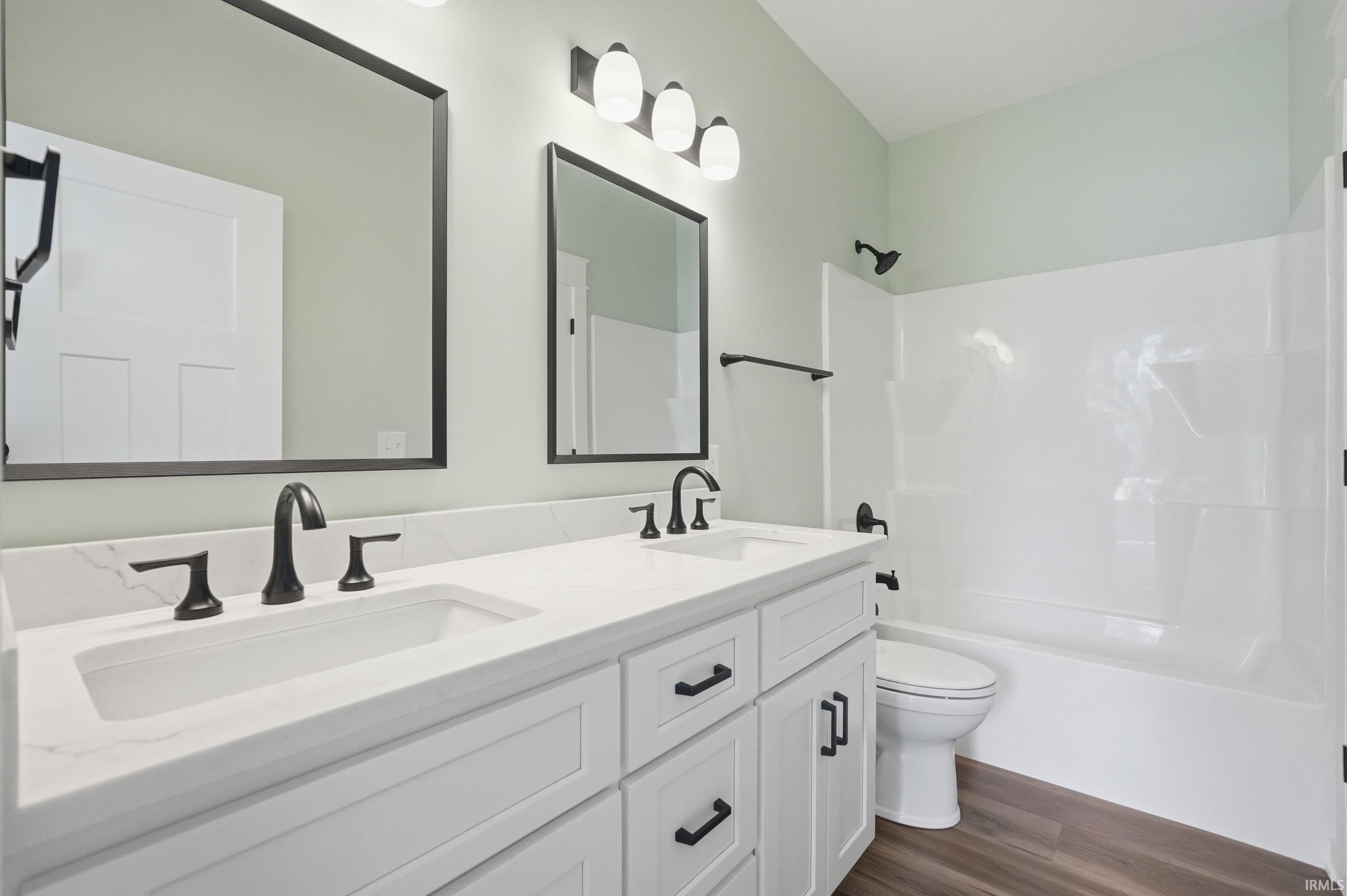 Double vanity with white cabinetry, matte black hardware, and integrated rectangular sinks