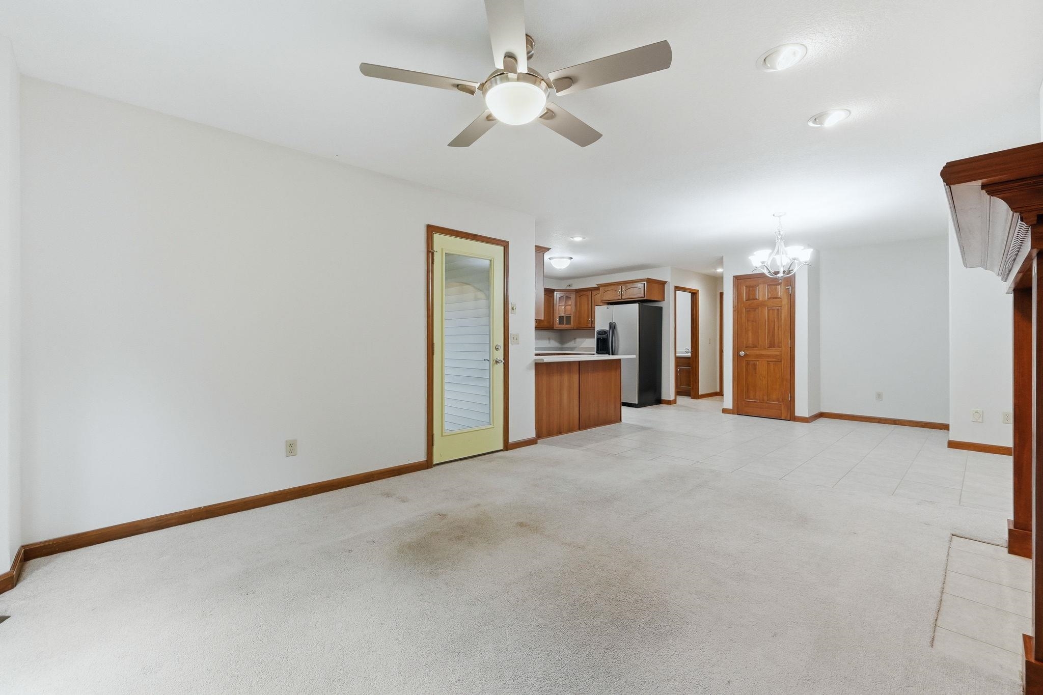 Open-concept living area featuring a ceiling fan, recessed lighting, and a neutral color palette