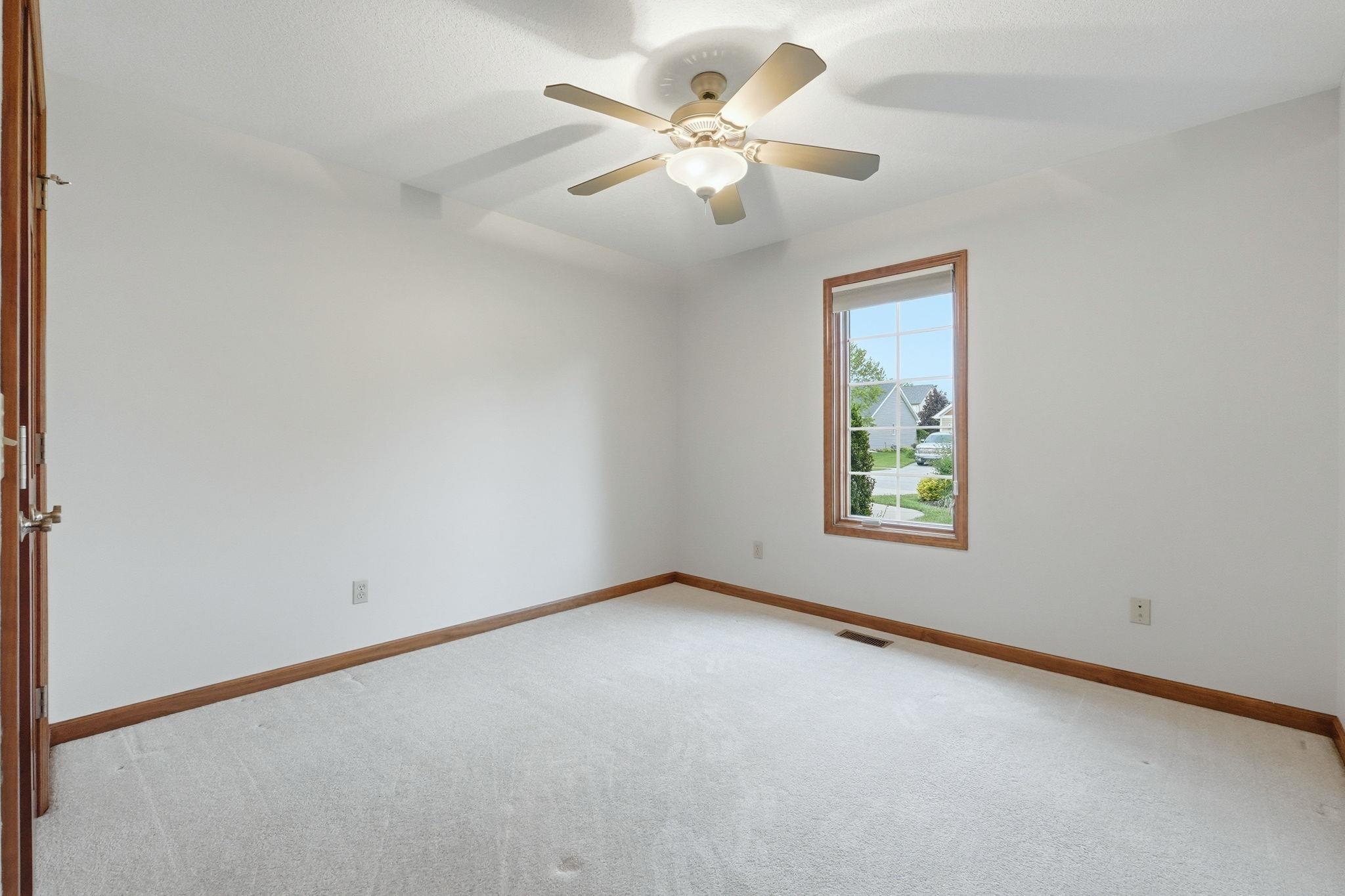 Neutral wall finishes featuring a single window with wood trim