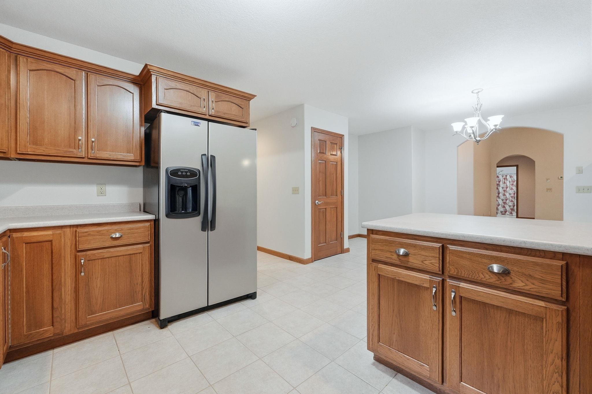 Kitchen featuring wood cabinetry, light countertops, and tile flooring