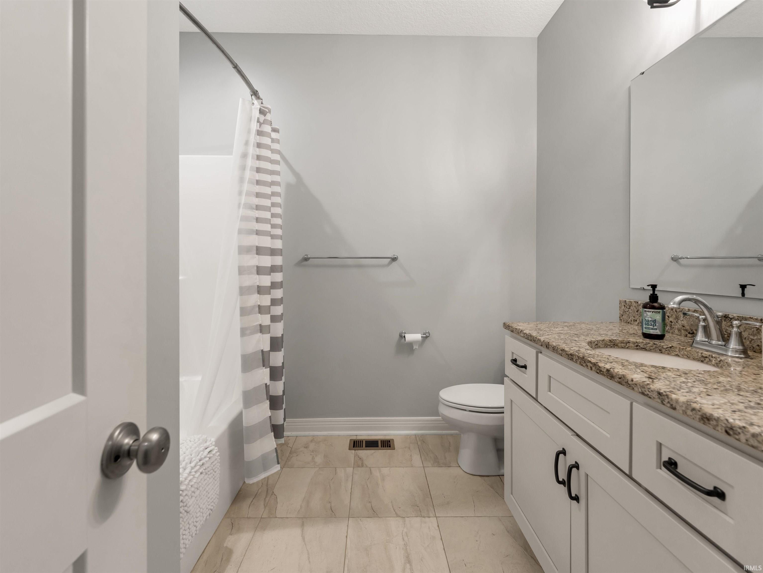 Bathroom featuring a white vanity with a granite countertop, undermount sink, and chrome faucet