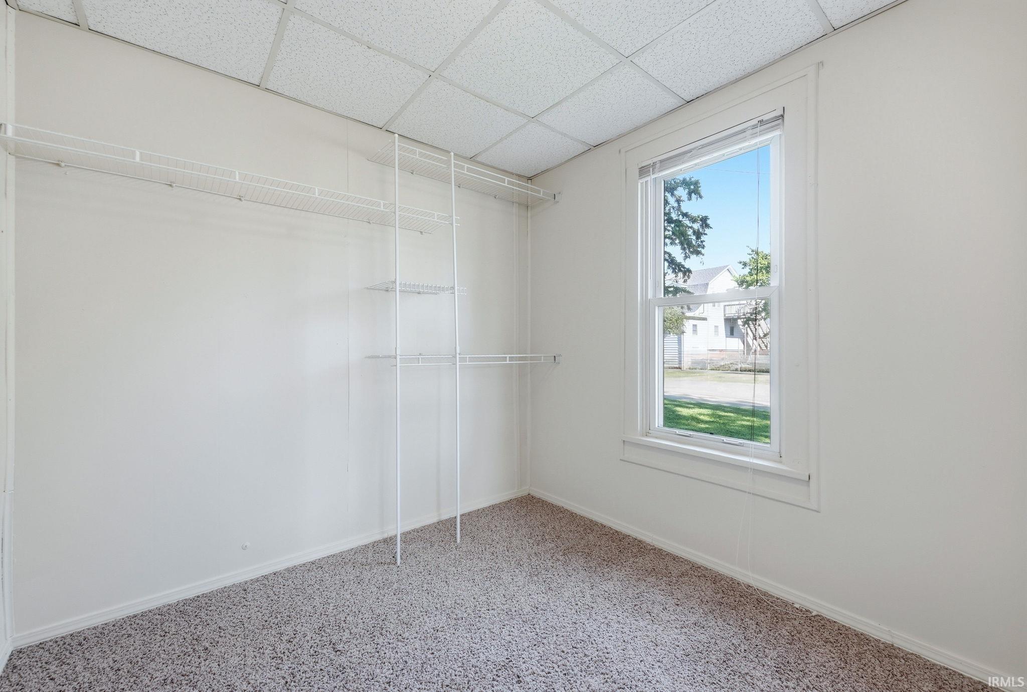 Room with neutral wall paint, textured ceiling, and carpeted flooring