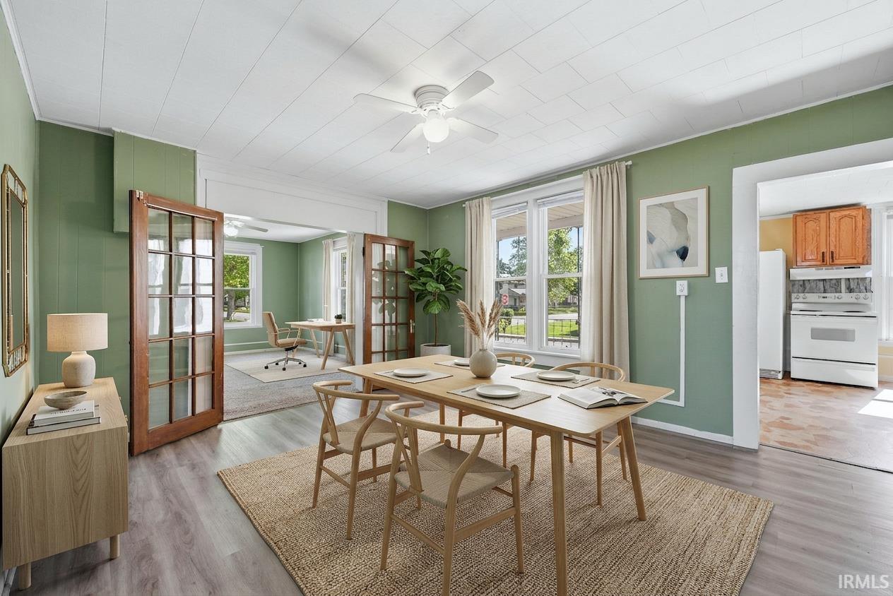 Dining area featuring wood-finish flooring, light green wall paint, and a ceiling fan