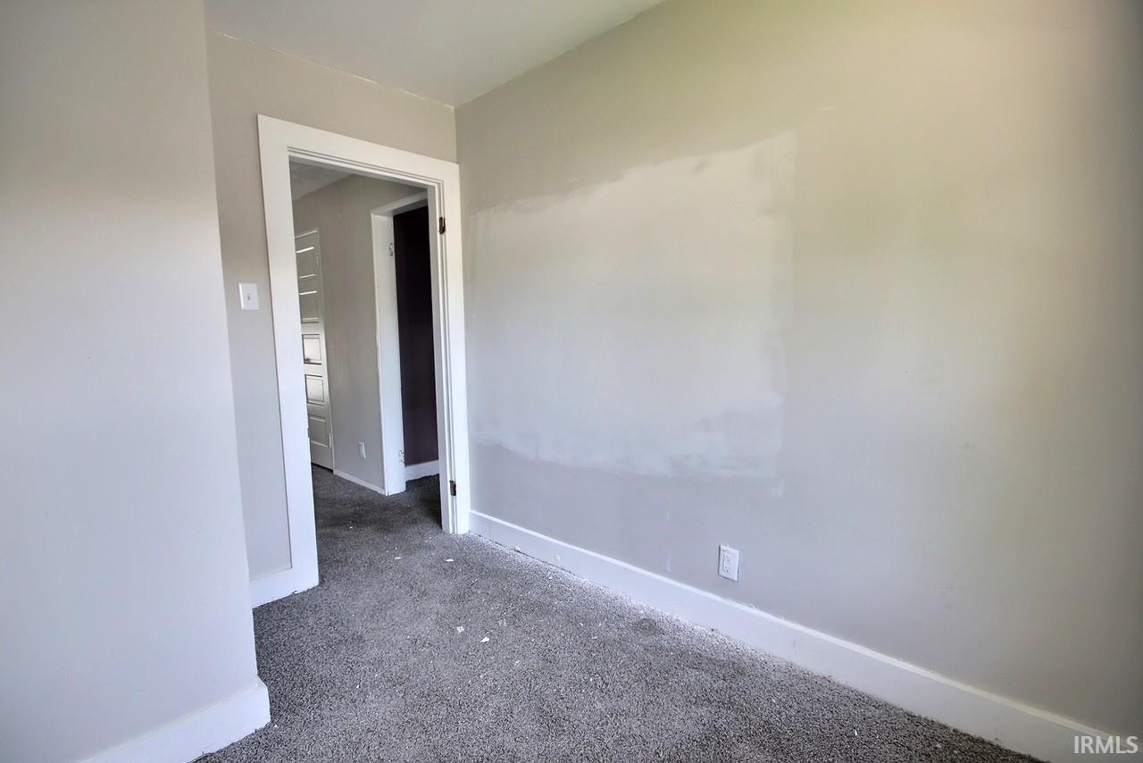 Room featuring light gray walls, white baseboards, and gray carpeting