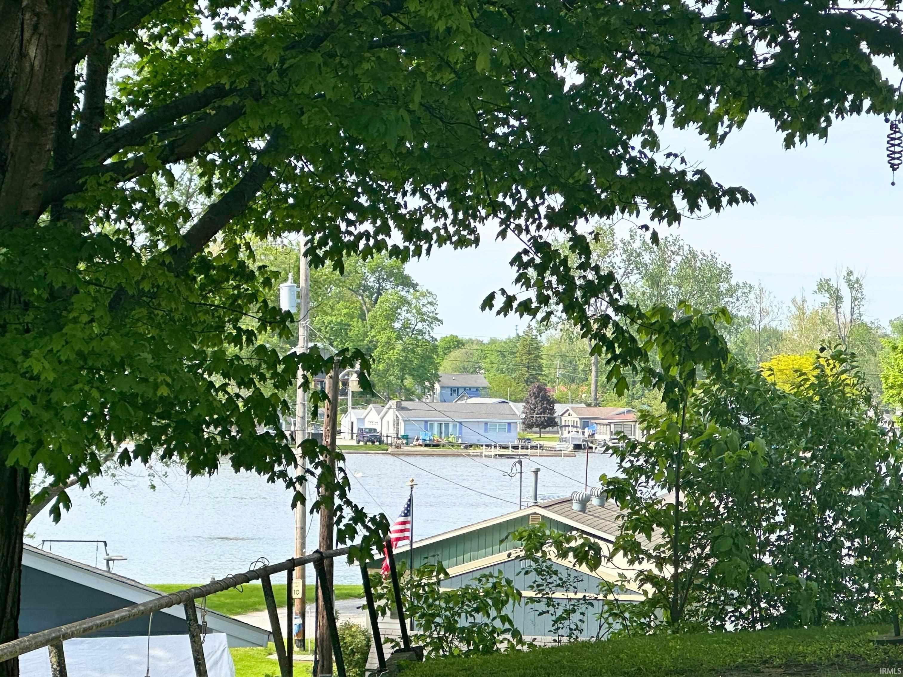 Waterfront perspective featuring mature trees framing the lake