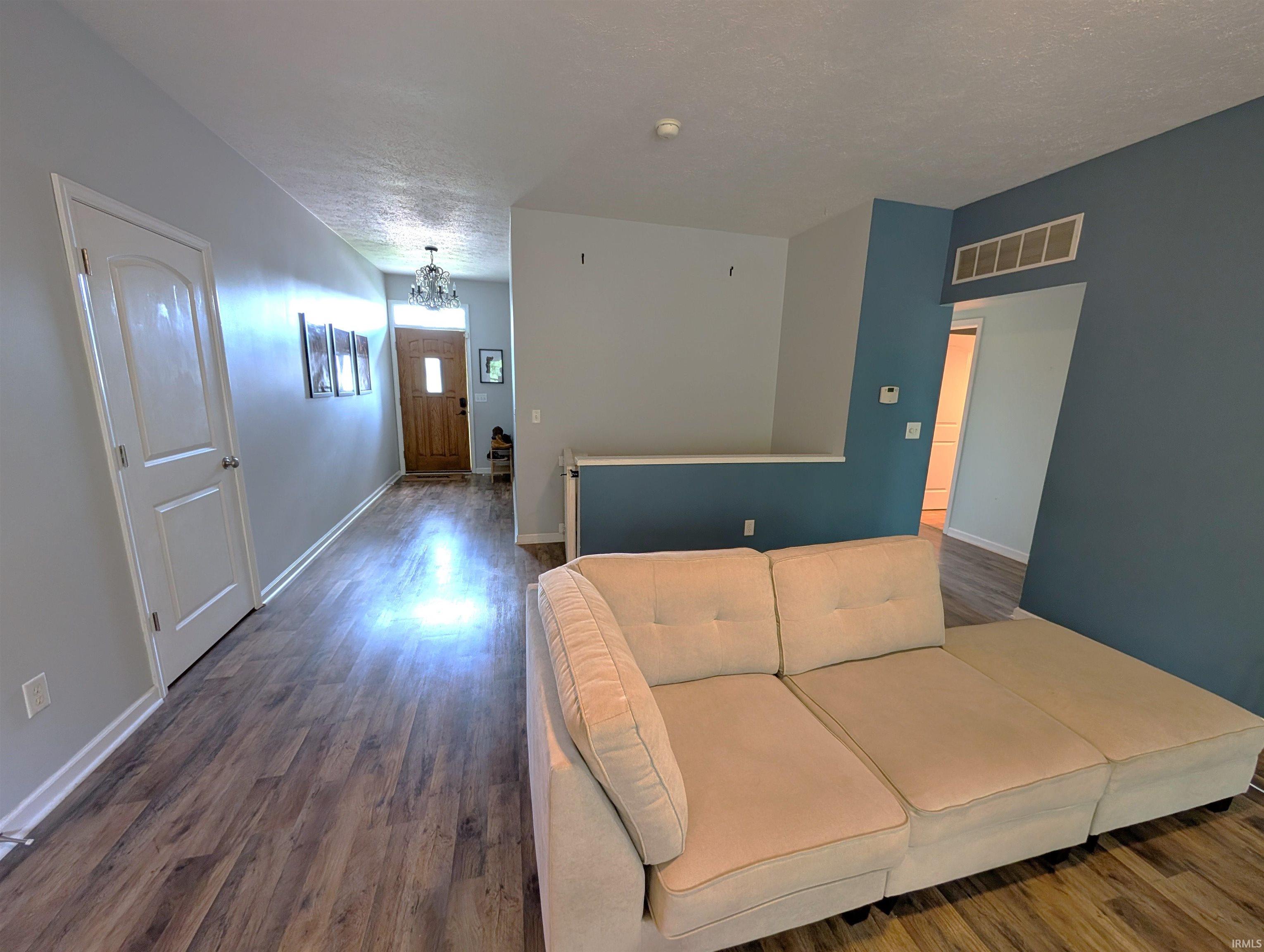 Open living space featuring wood-finish flooring, two-tone wall paint, and white trim