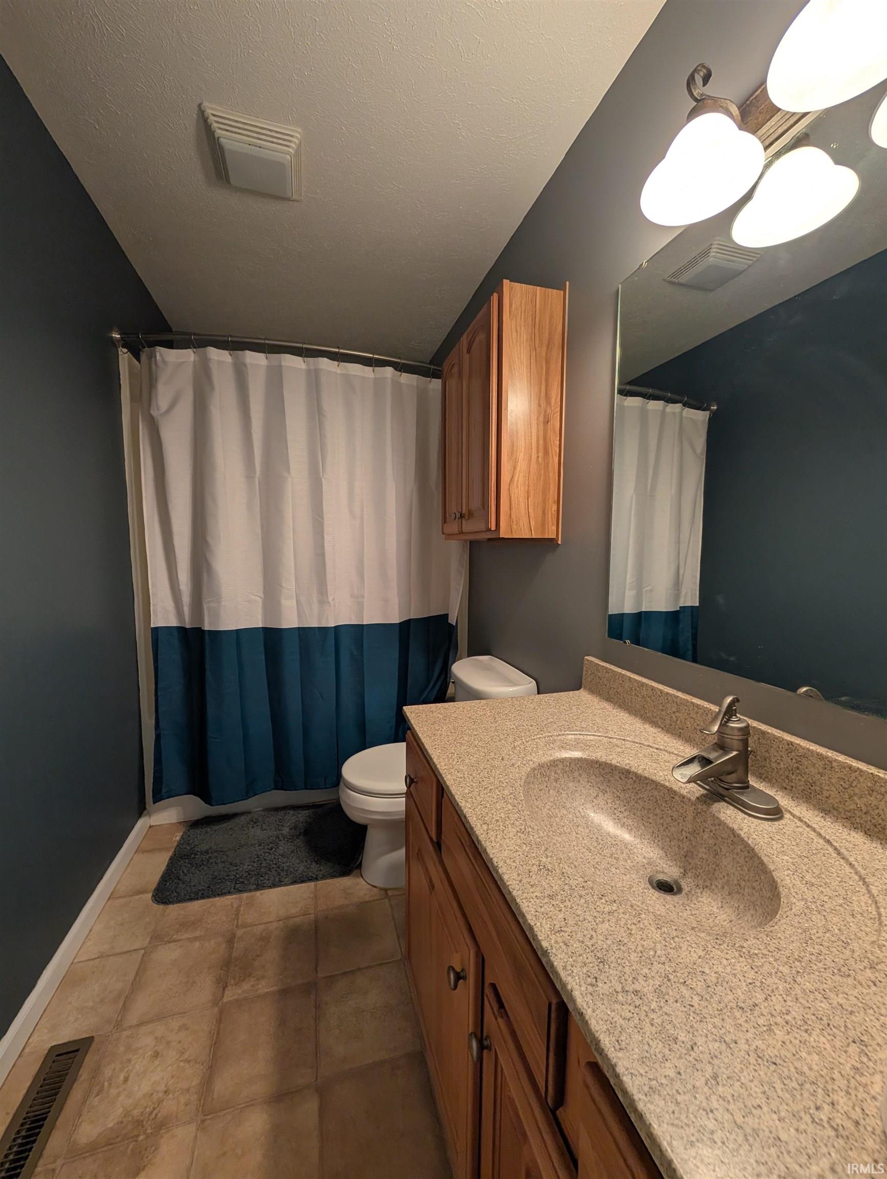 Bathroom featuring a vanity with an integrated sink, a single-handle faucet, and wood-finish cabinetry
