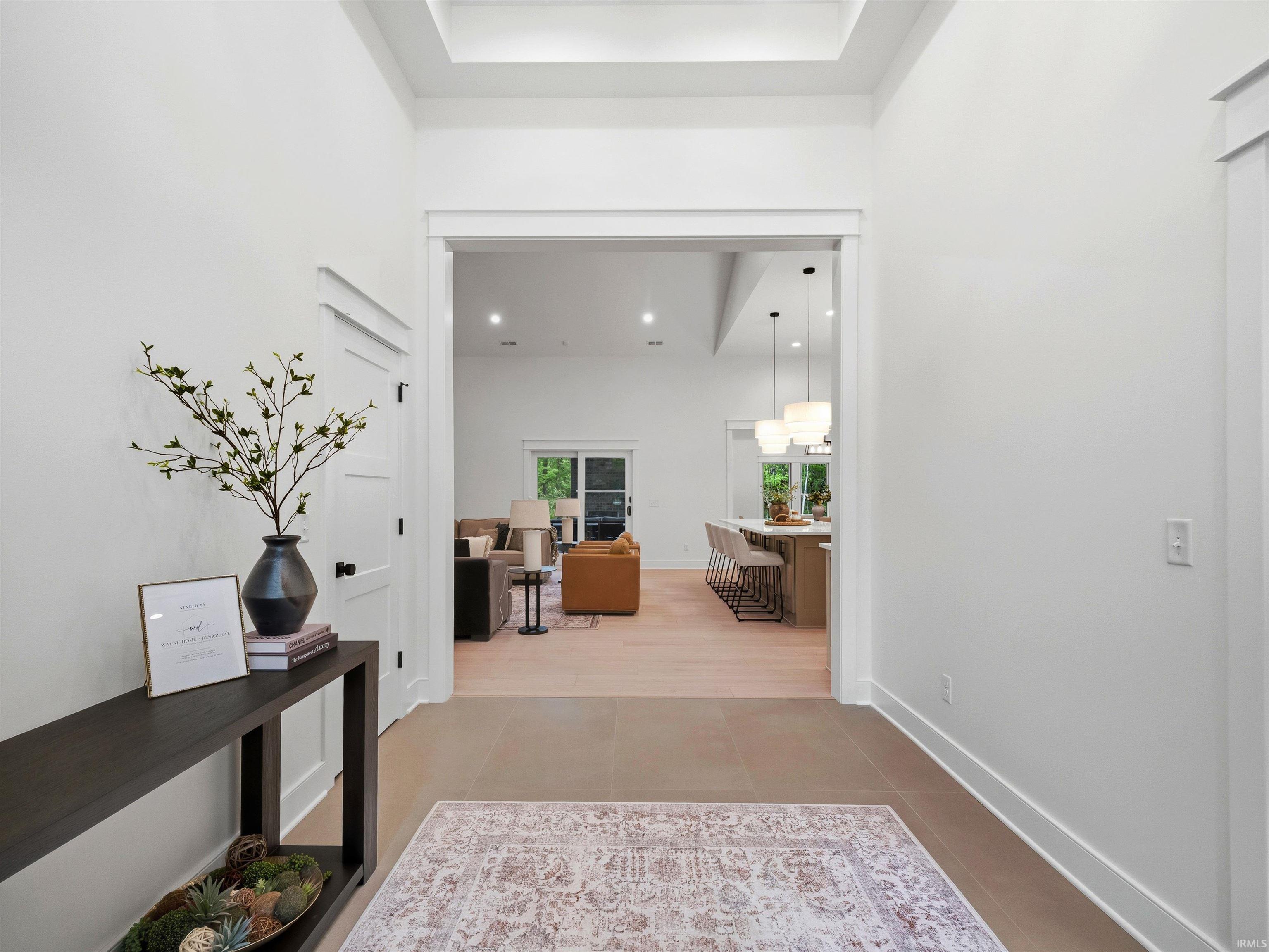 Entryway featuring tile flooring, white baseboards, and a tray ceiling