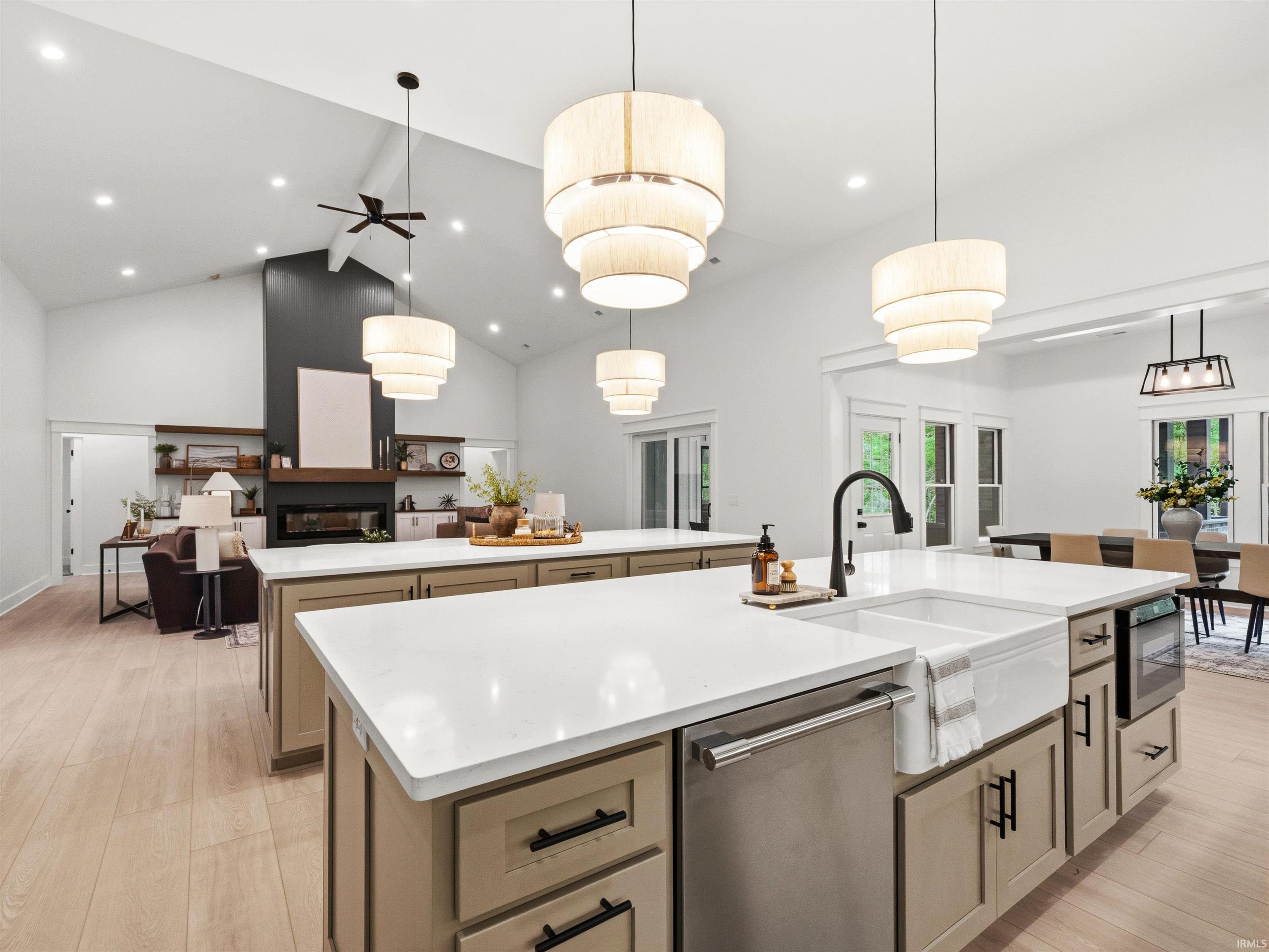 Kitchen island featuring a farmhouse sink with a matte black faucet, integrated dishwasher, and built-in microwave drawer