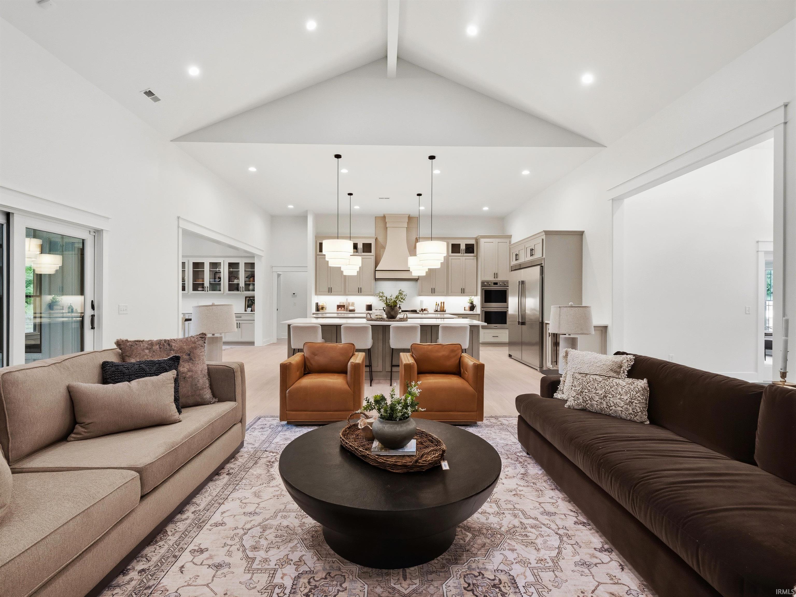 Spacious great room featuring vaulted ceilings, recessed lighting, and wood-finish flooring