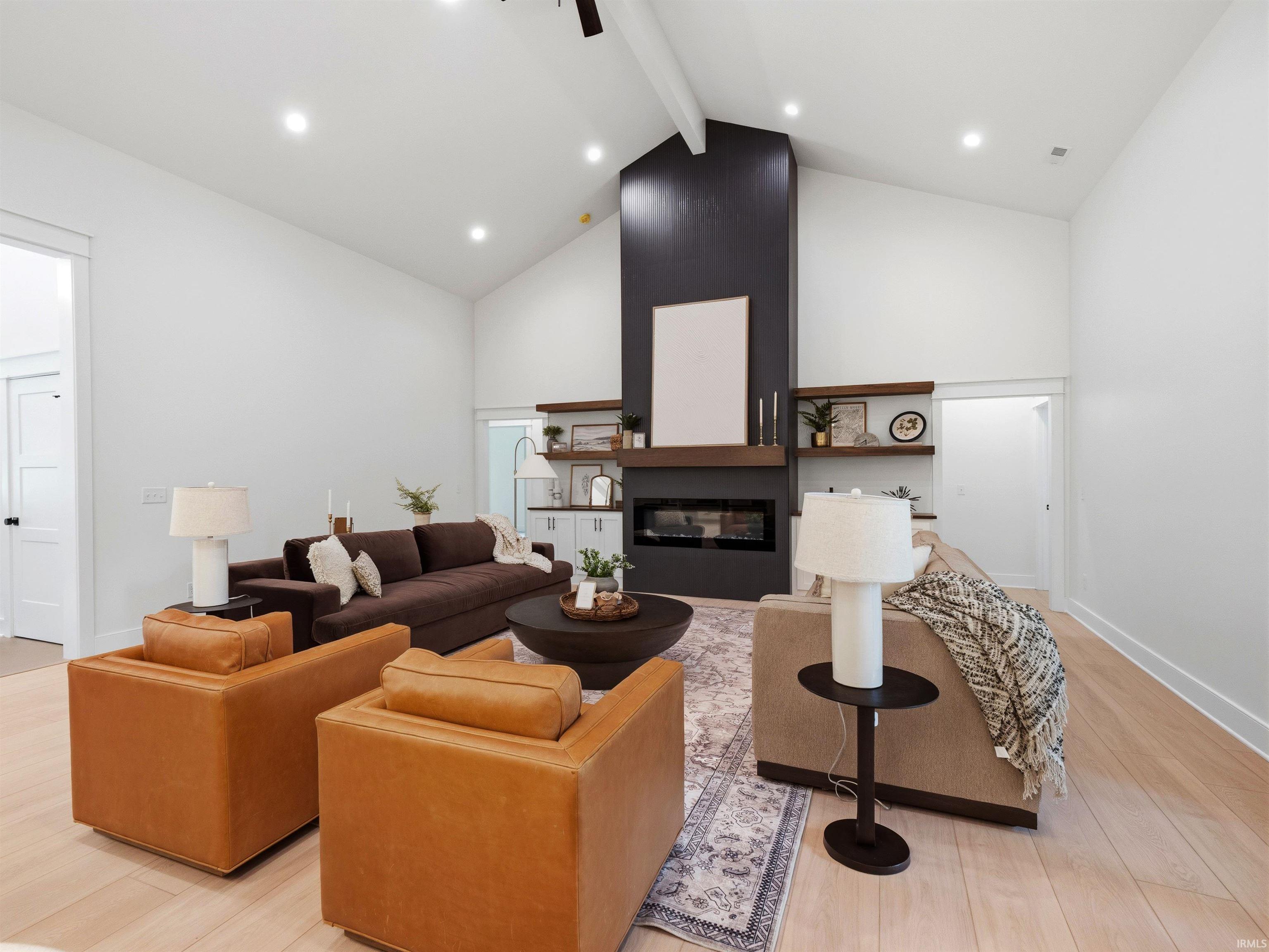 Vaulted ceilings over a central fireplace with dark paneling and a wood mantel