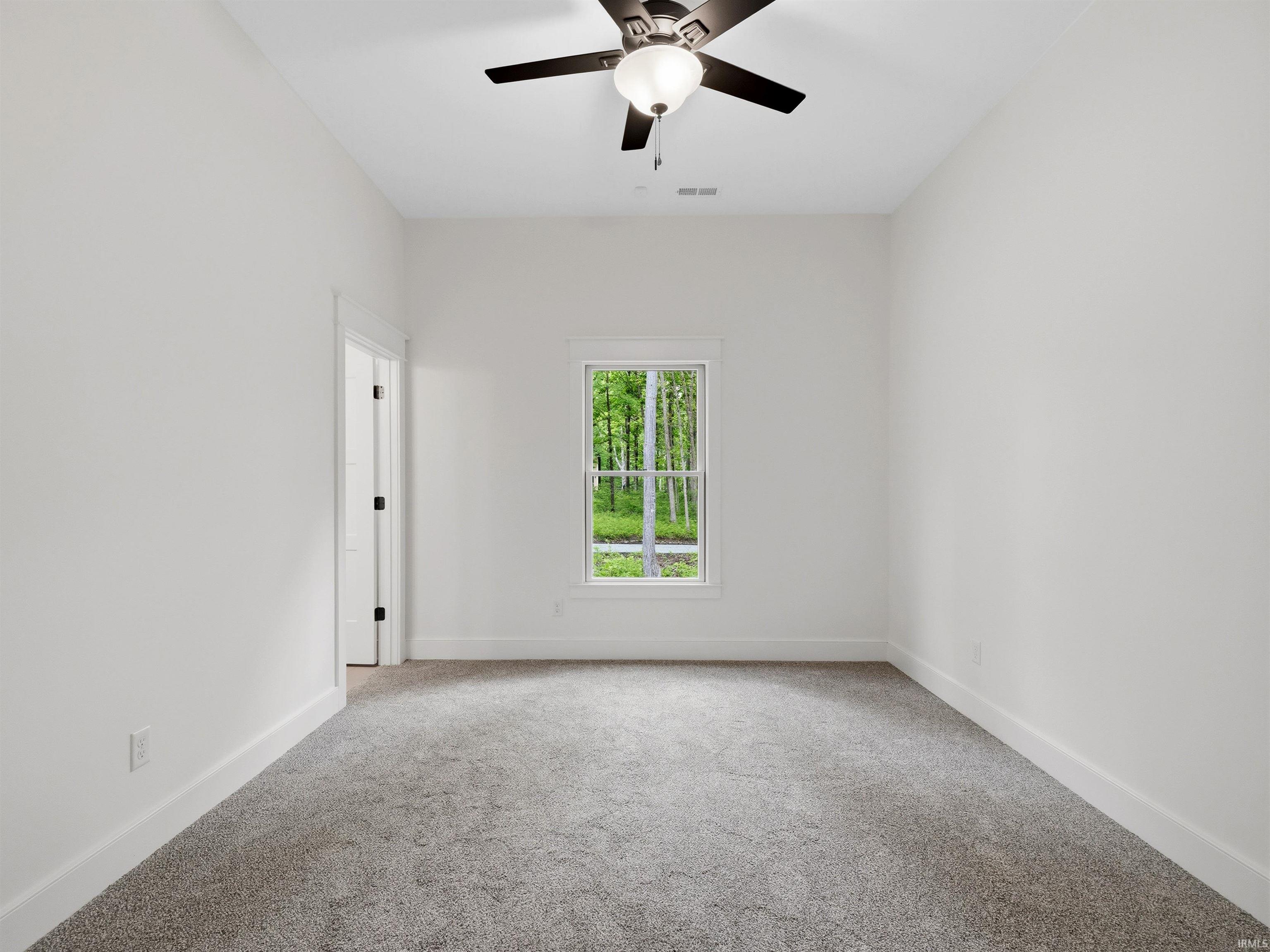 Bright room featuring a ceiling fan with integrated lighting, light gray carpet, and white trim