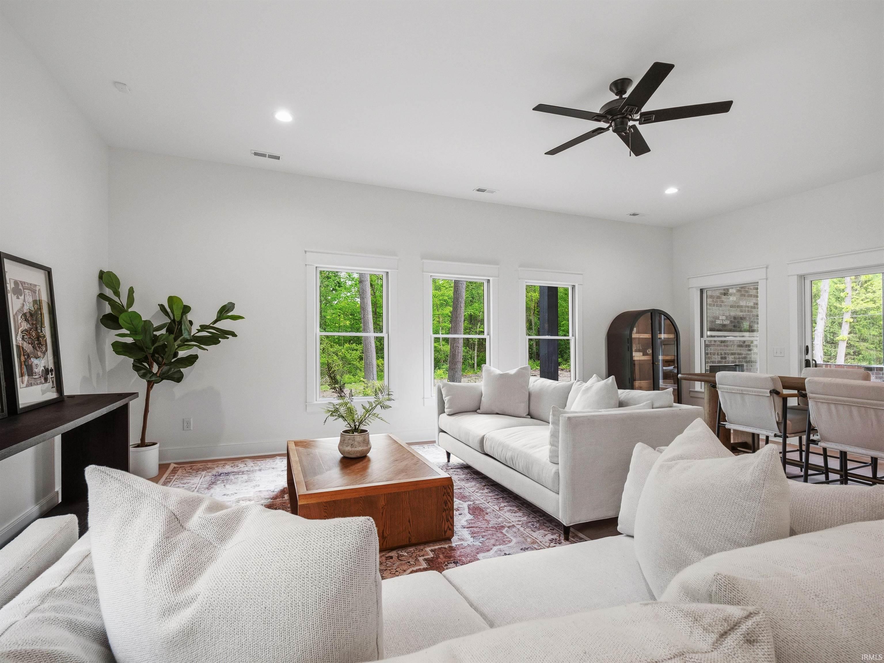 Bright living area featuring multiple windows, recessed lighting, and a modern ceiling fan
