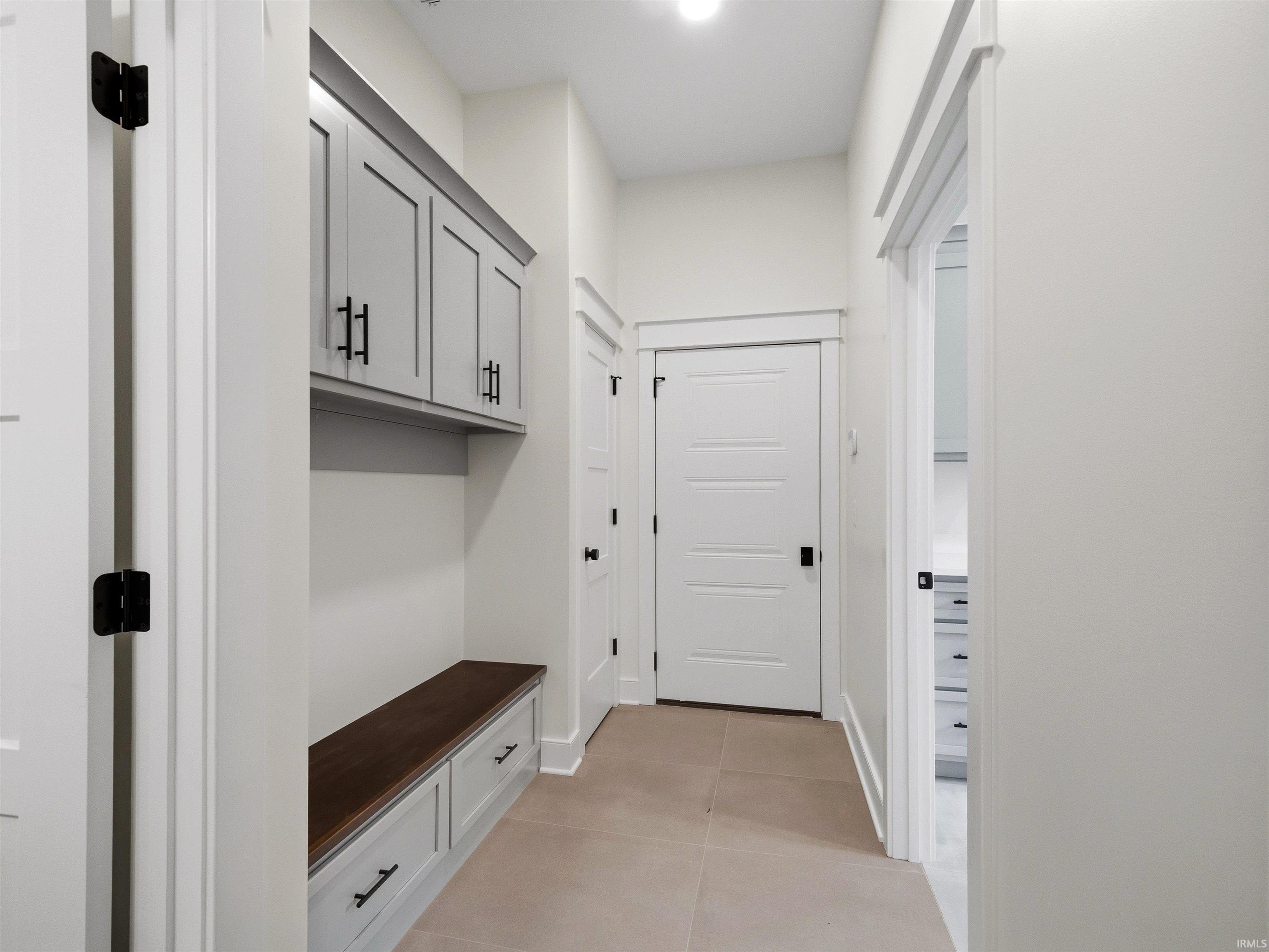 Hallway mudroom featuring a built-in bench with storage drawers and upper cabinetry