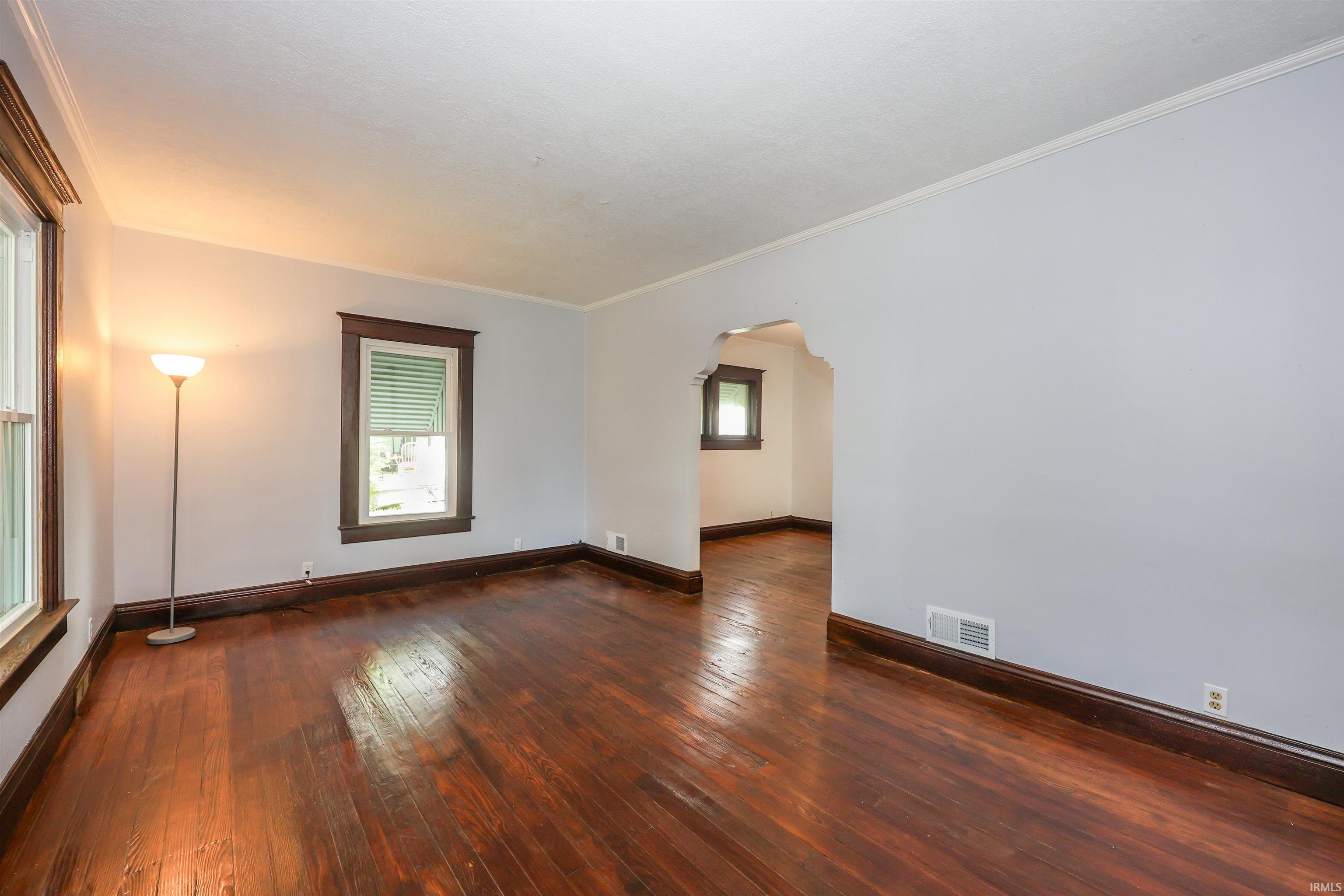 Hardwood flooring throughout featuring dark wood trim and baseboards