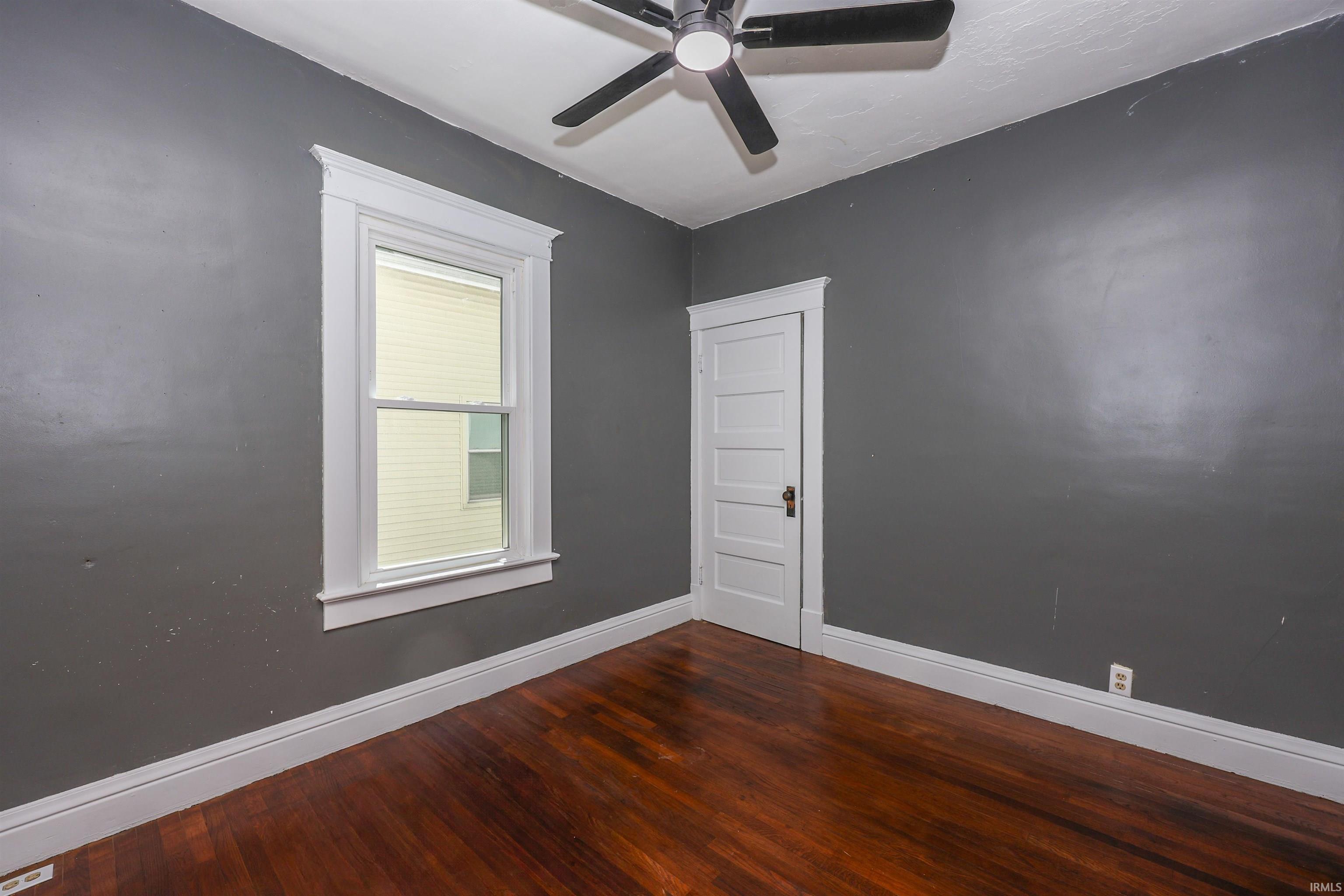 Rich wood-finish flooring complements the dark gray walls and white trim