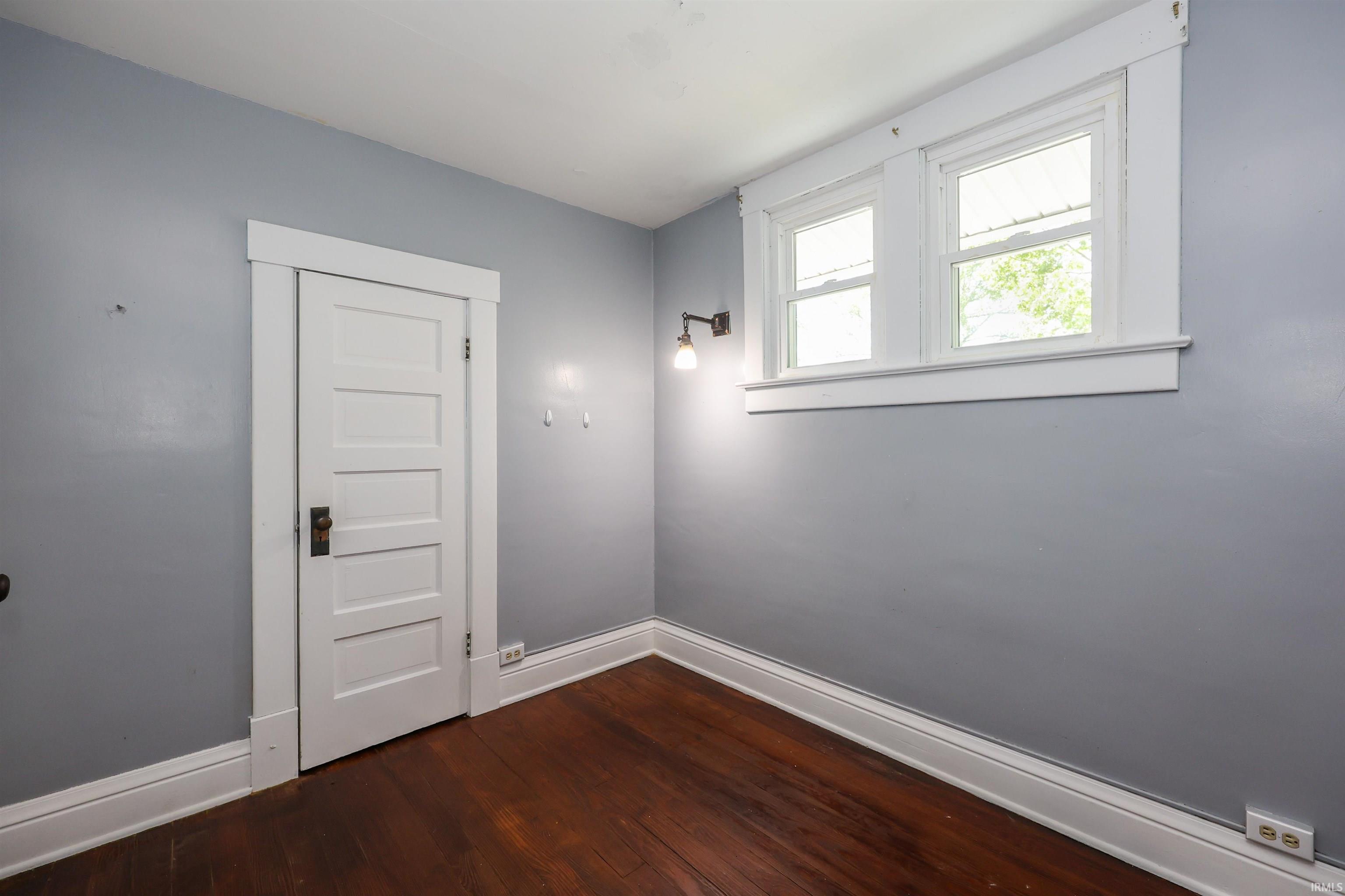 Interior room featuring wood-finish flooring, light gray walls, and white trim