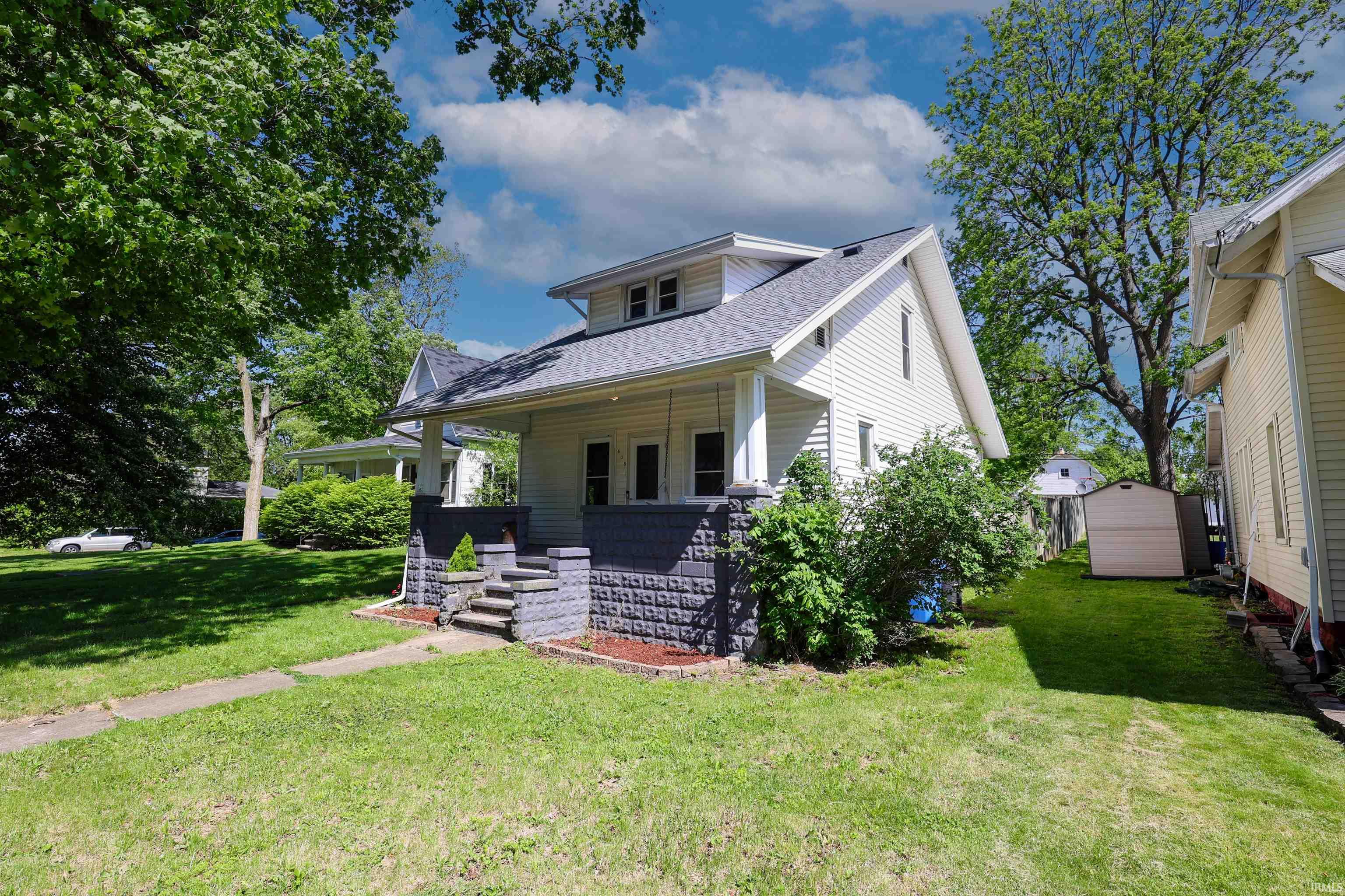 Charming two-story residence with white siding and a gray shingle roof