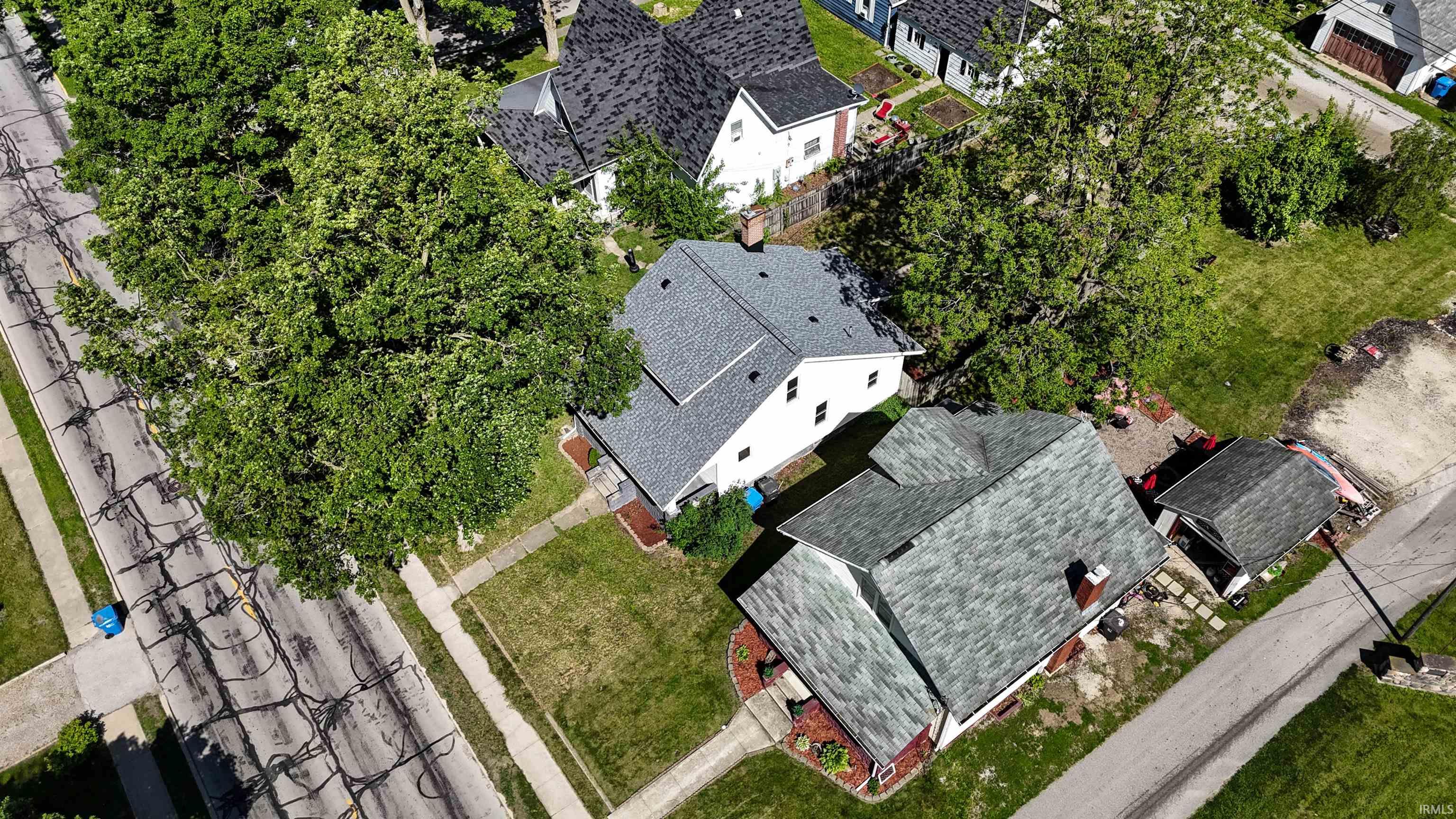 Aerial perspective of a neighborhood featuring multiple residential structures with varied roofing materials