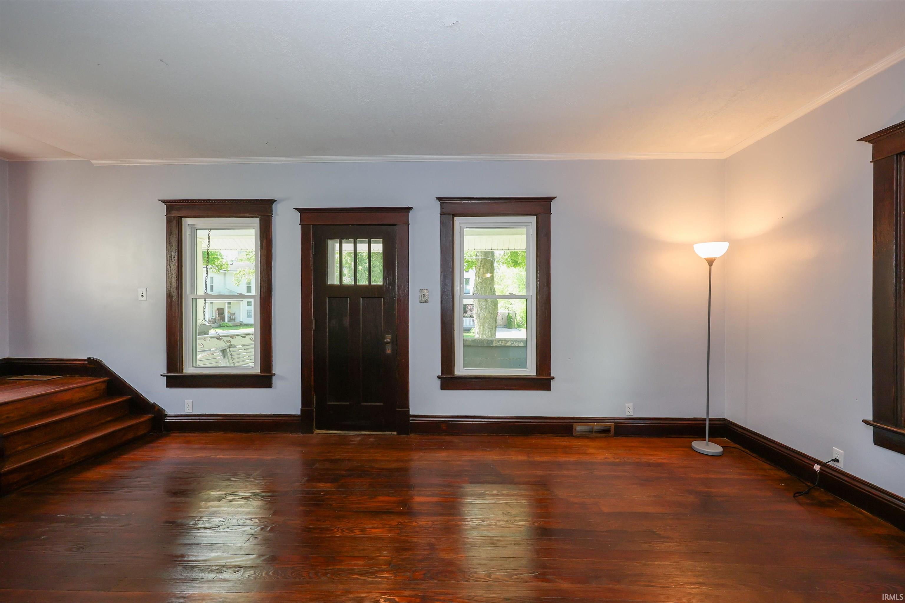 Hardwood flooring throughout featuring dark wood trim and baseboards