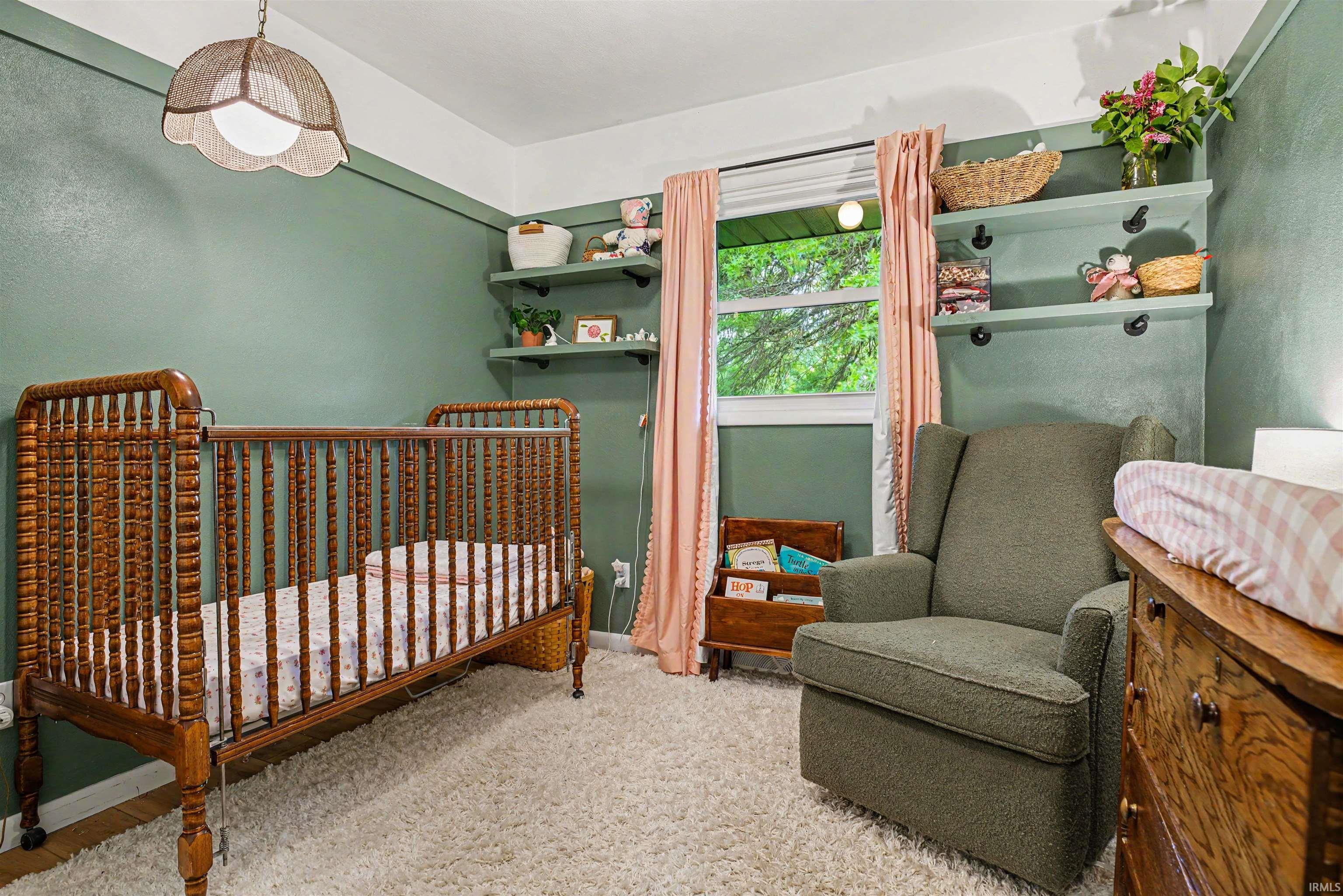 Room with painted accent wall, built-in shelving, and a large window