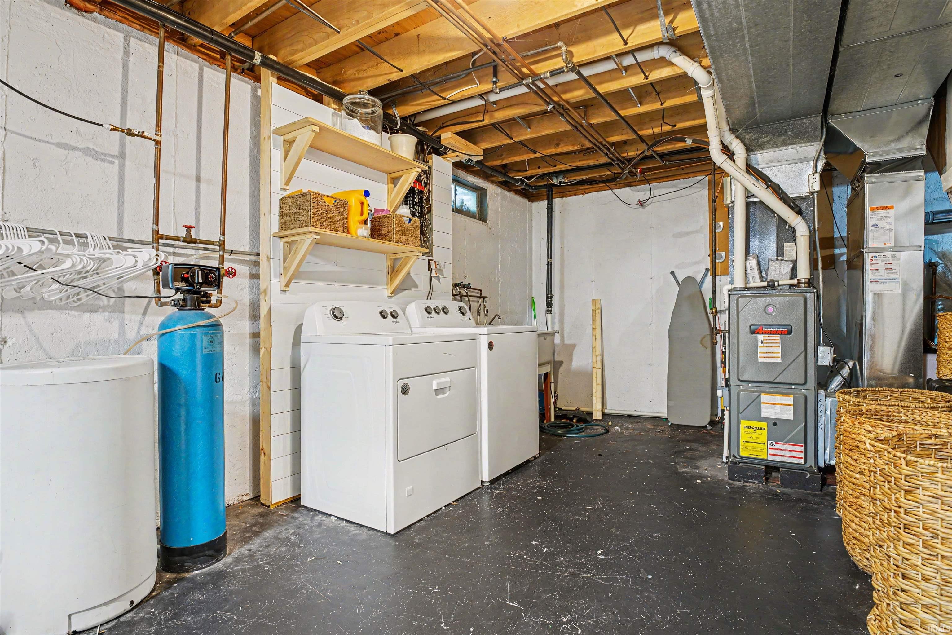Utility area featuring a water filtration system, exposed ceiling joists, and a furnace with visible ductwork