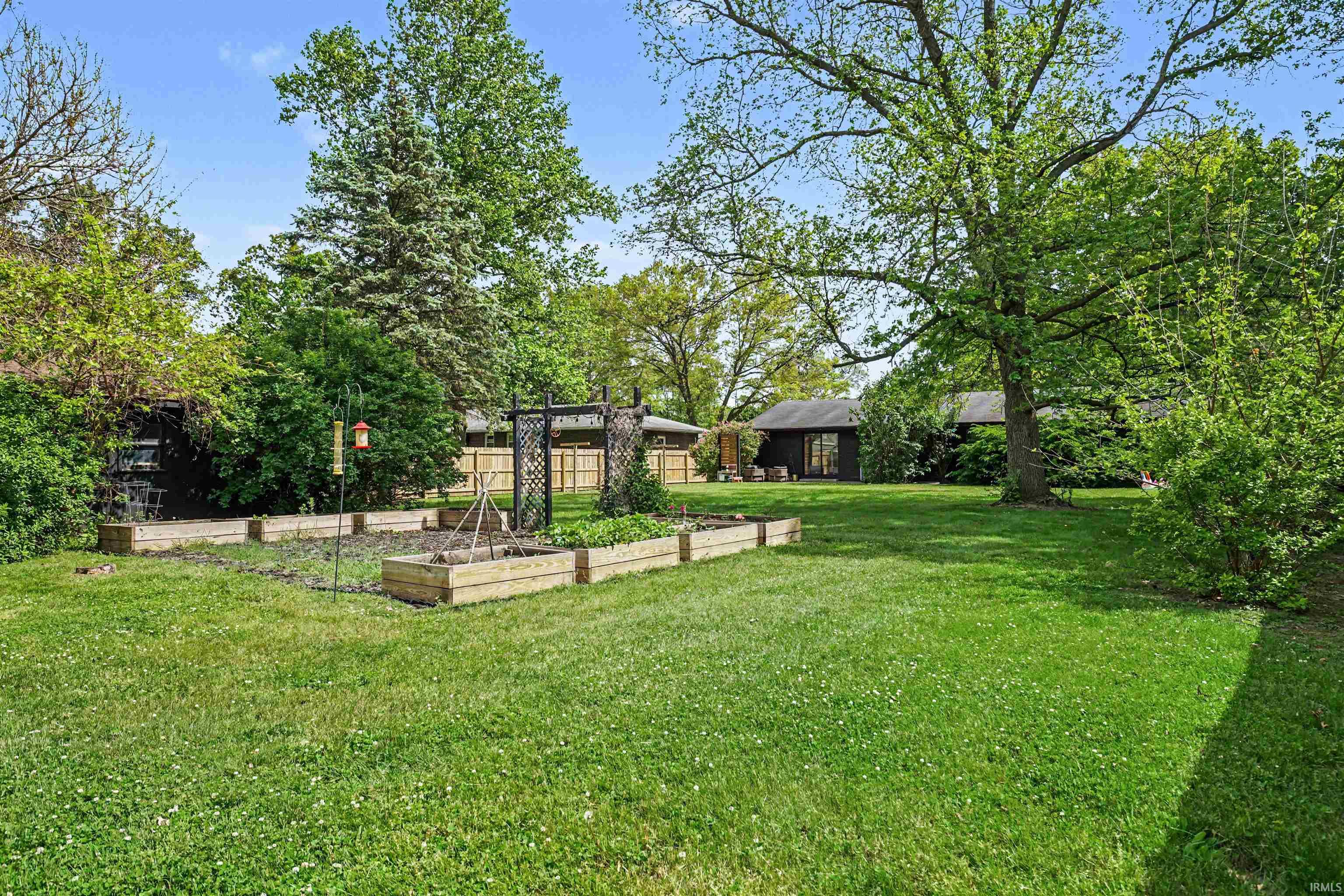Expansive green lawn featuring multiple raised garden beds