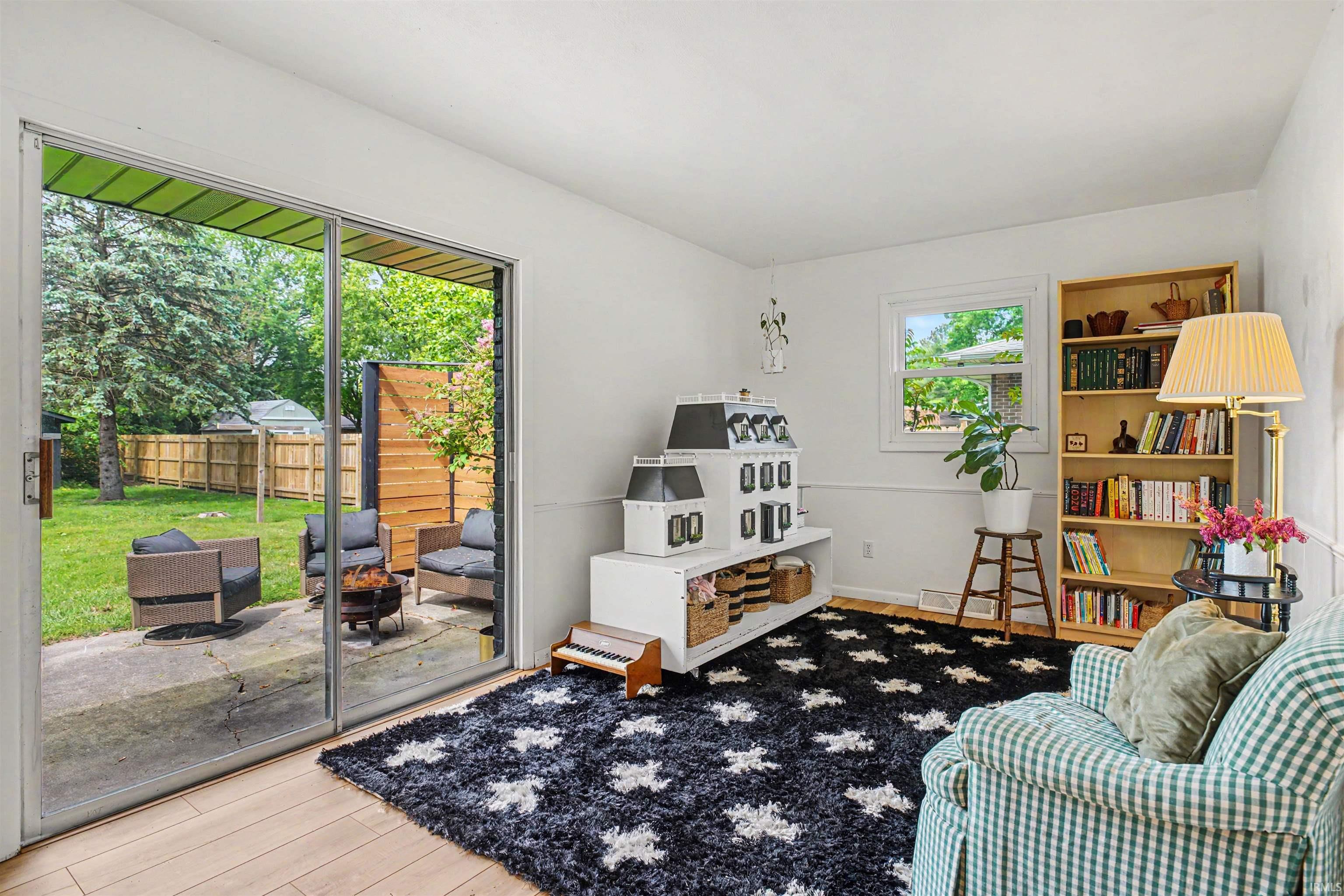 Sliding glass door opening to an outdoor patio with a fire pit