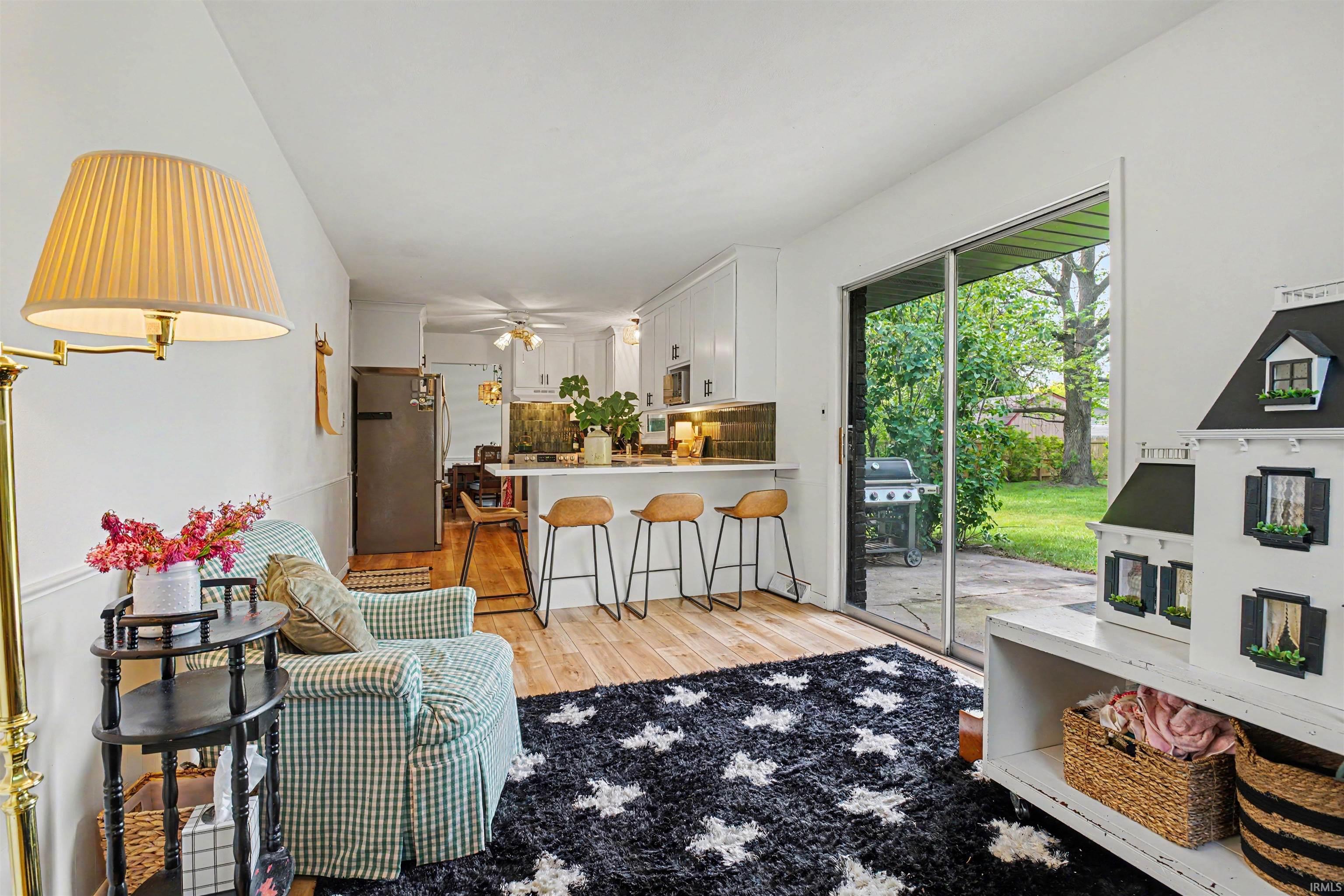 Living area with wood-finish flooring and direct access to a paved patio