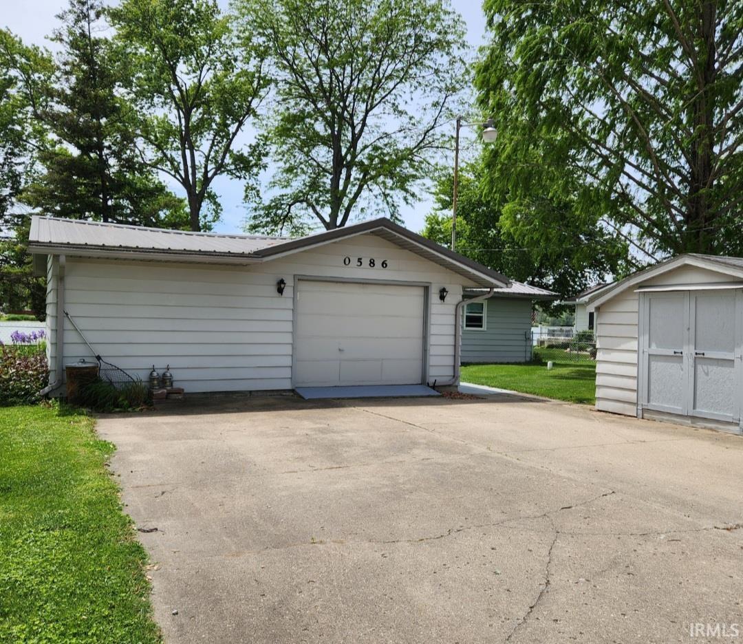 Attached single-car garage featuring a white overhead door and exterior lighting