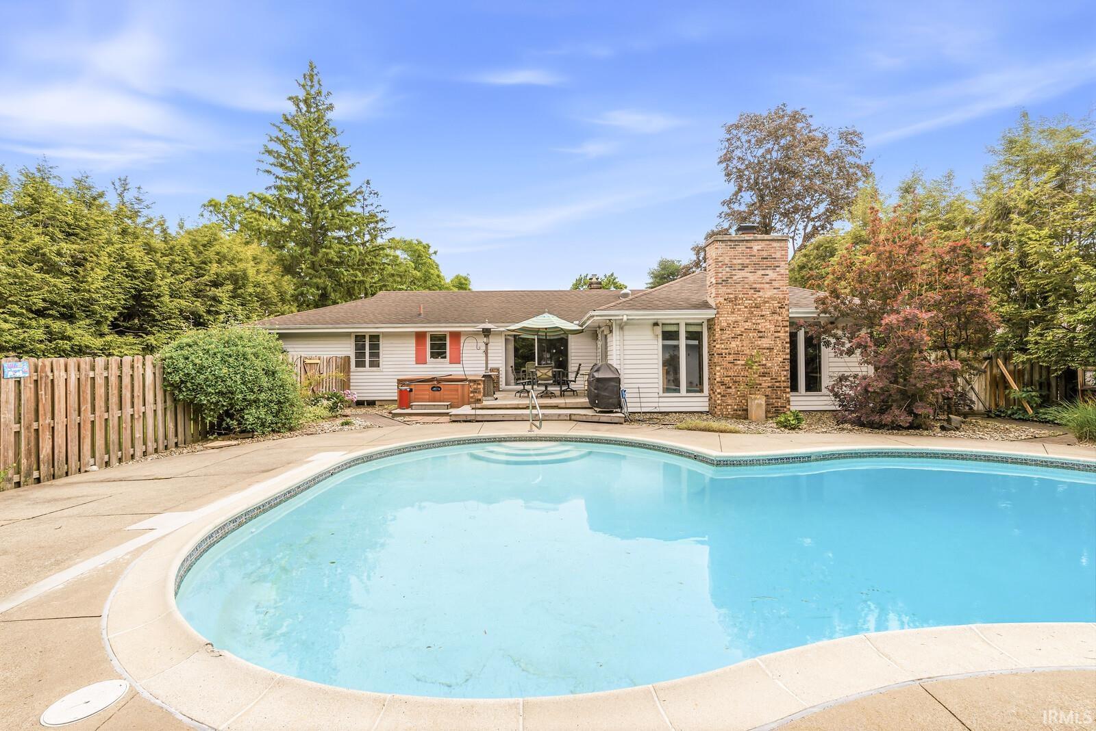 Curved inground pool with concrete surround