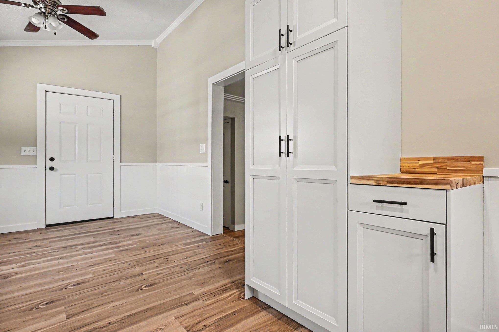 Interior space featuring wood-finish flooring, white wainscoting, and neutral-toned walls
